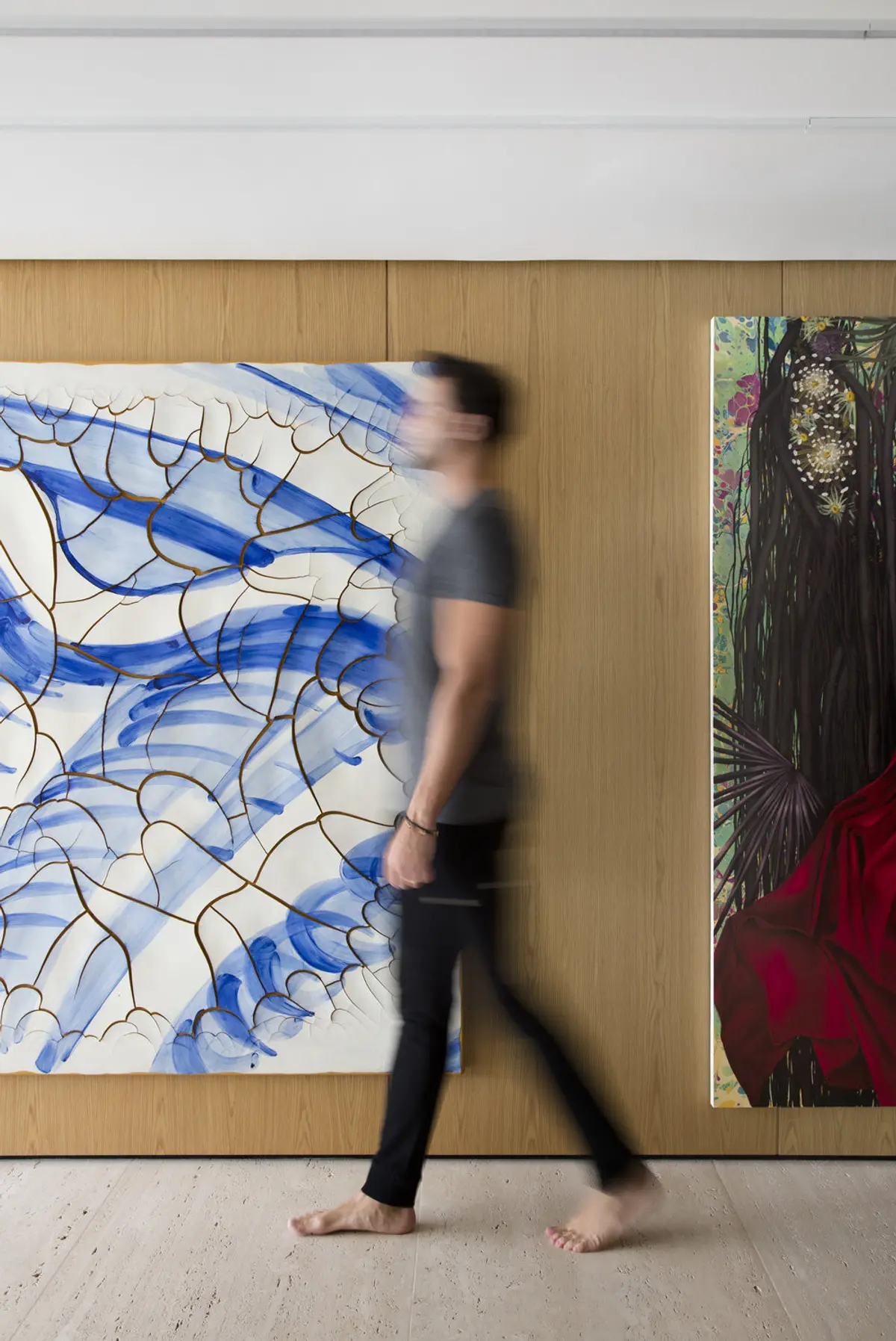 Persona camina frente a obras de arte abstracto en pasillo moderno — proyecto RM House, por Studio Ro-ca