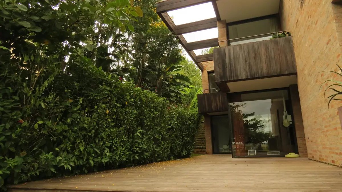 Patio con deck de madera, jardin vertical y pergola moderna — proyecto Residência MP, por Gil Fialho