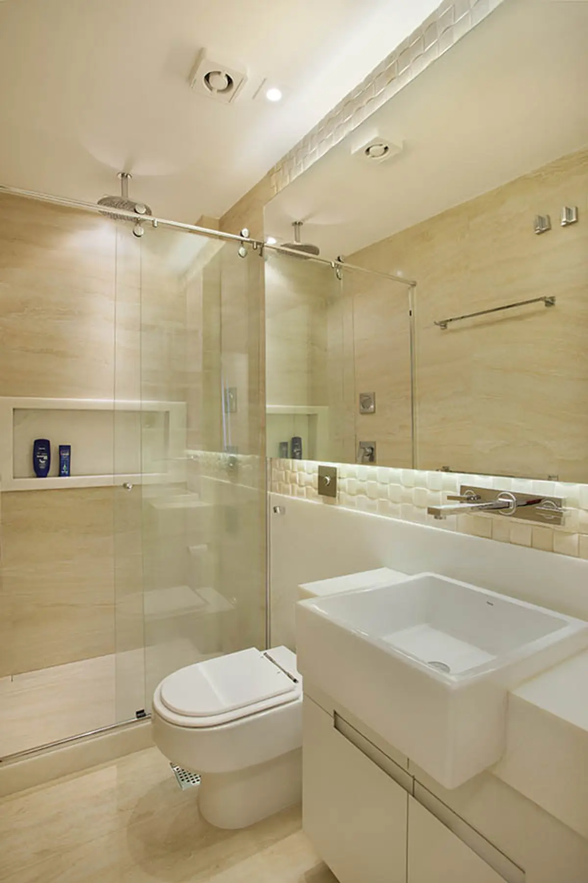 Bano moderno con ducha de vidrio, inodoro blanco y mesada flotante — proyecto Apartamento Recreio, por Amanda Miranda
