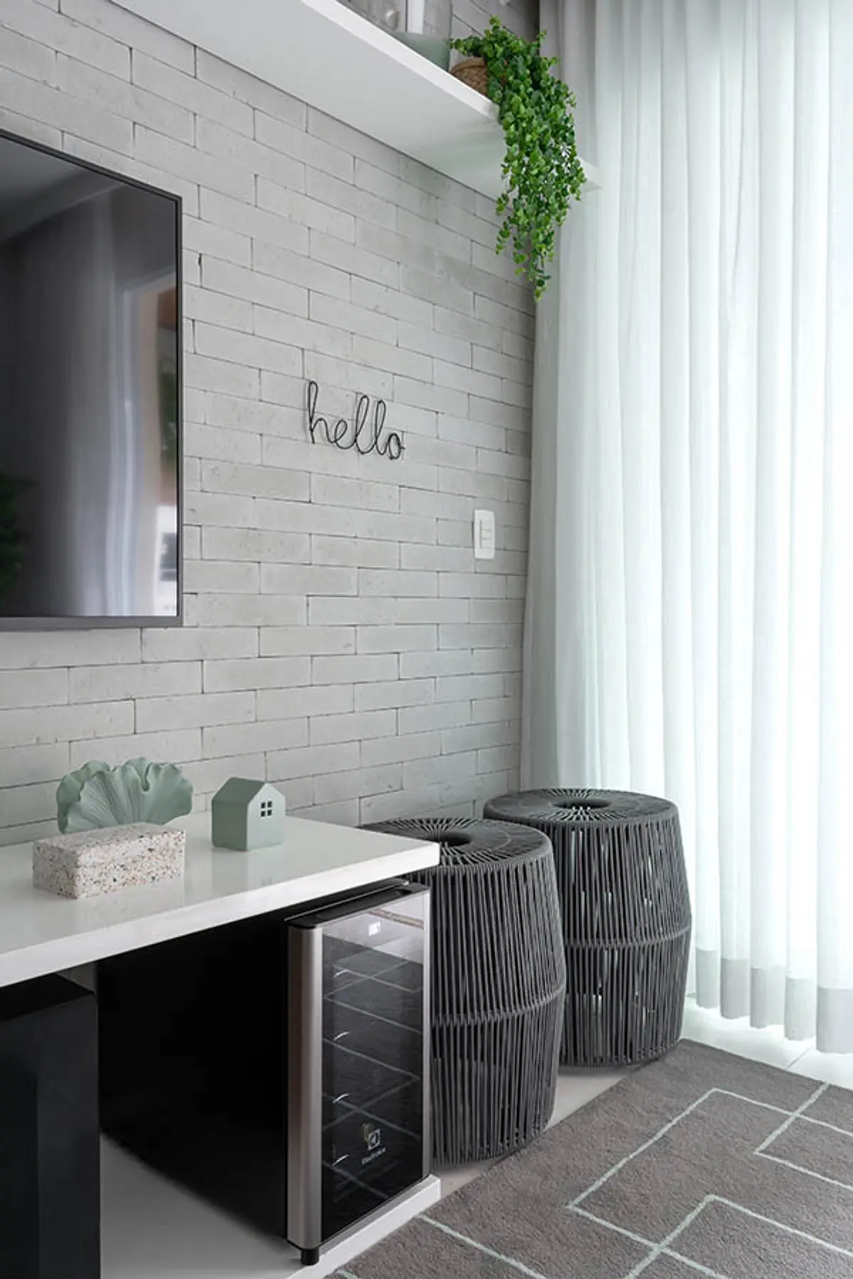 Oficina minimalista con pared de ladrillo blanco y plantas colgantes — proyecto Apartamento Nóbrega, por Amanda Miranda