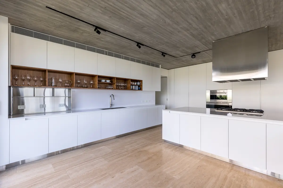 Cozinha moderna minimalista com teto de concreto aparente e móveis brancos — projeto Propiedad en Nordelta, por MARCO GUOLI PHOTO, em Nordelta