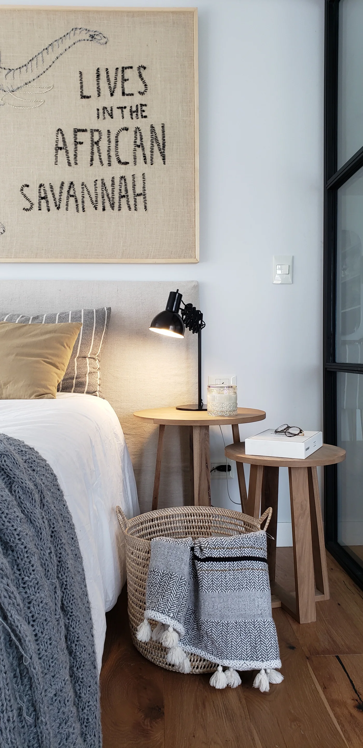 Dormitorio moderno con arte gráfico y textiles acogedores.