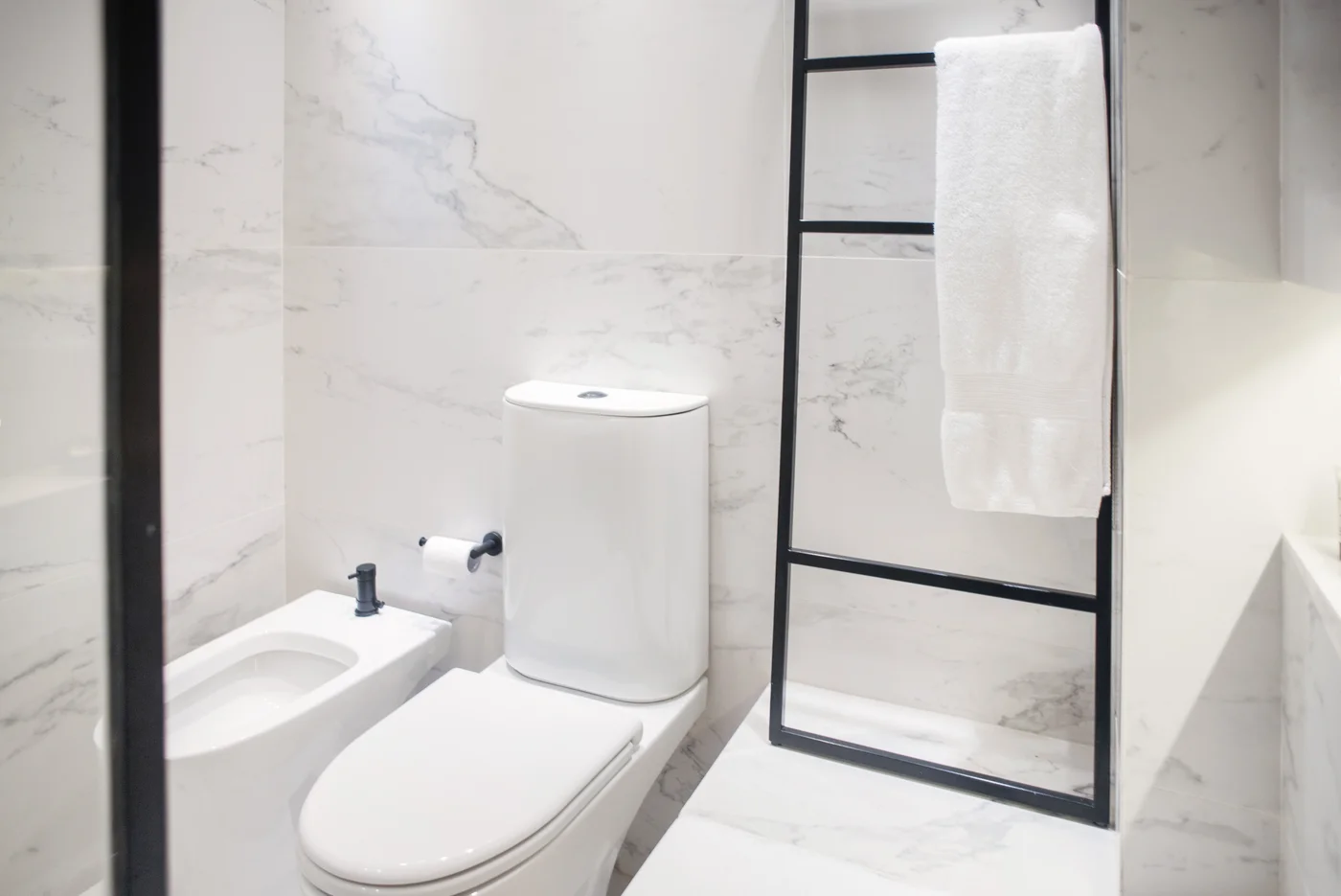 Baño moderno con mármol blanco y estantería tipo escalera