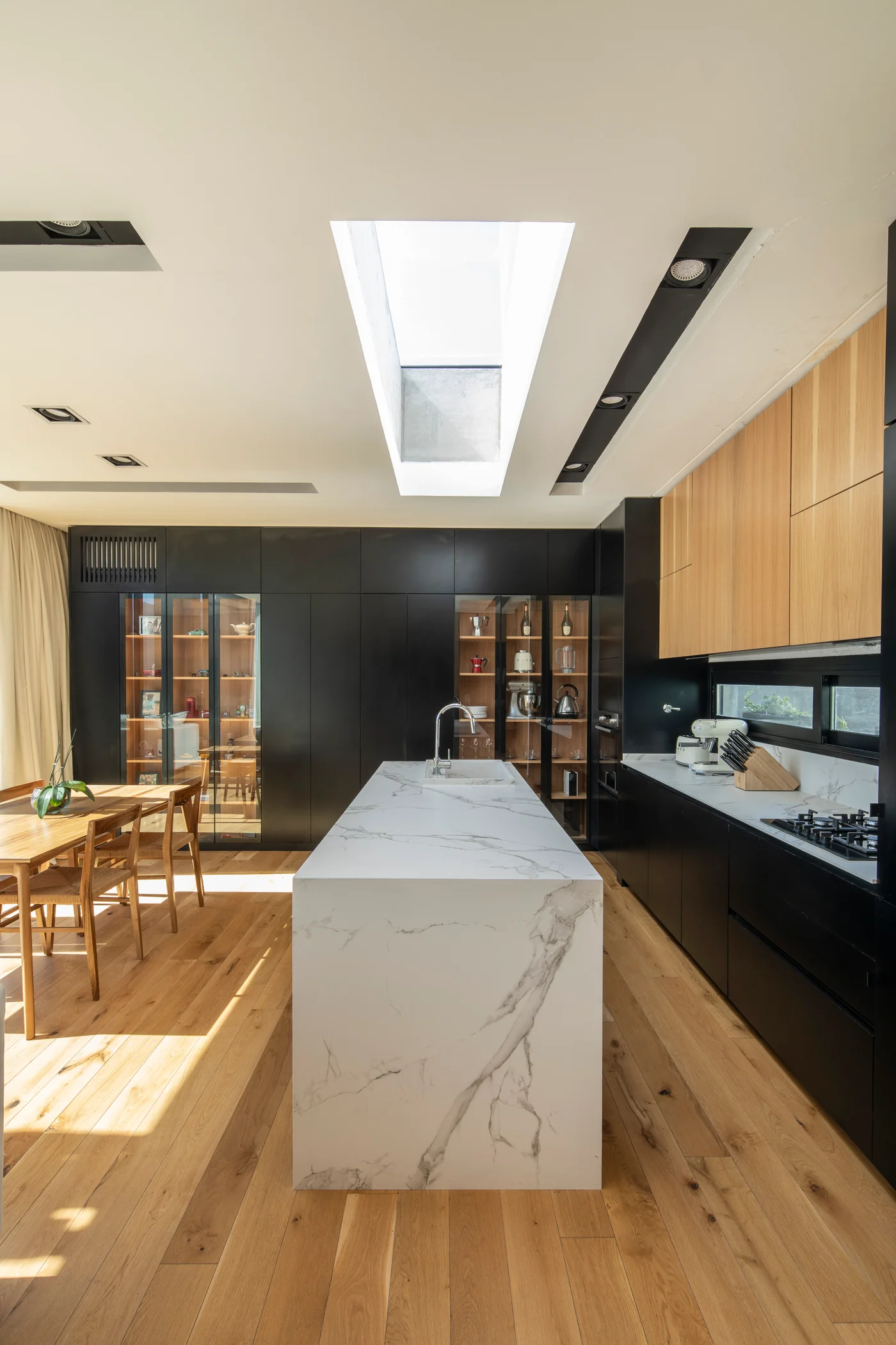 Cocina moderna con isla grande de mármol y claraboya