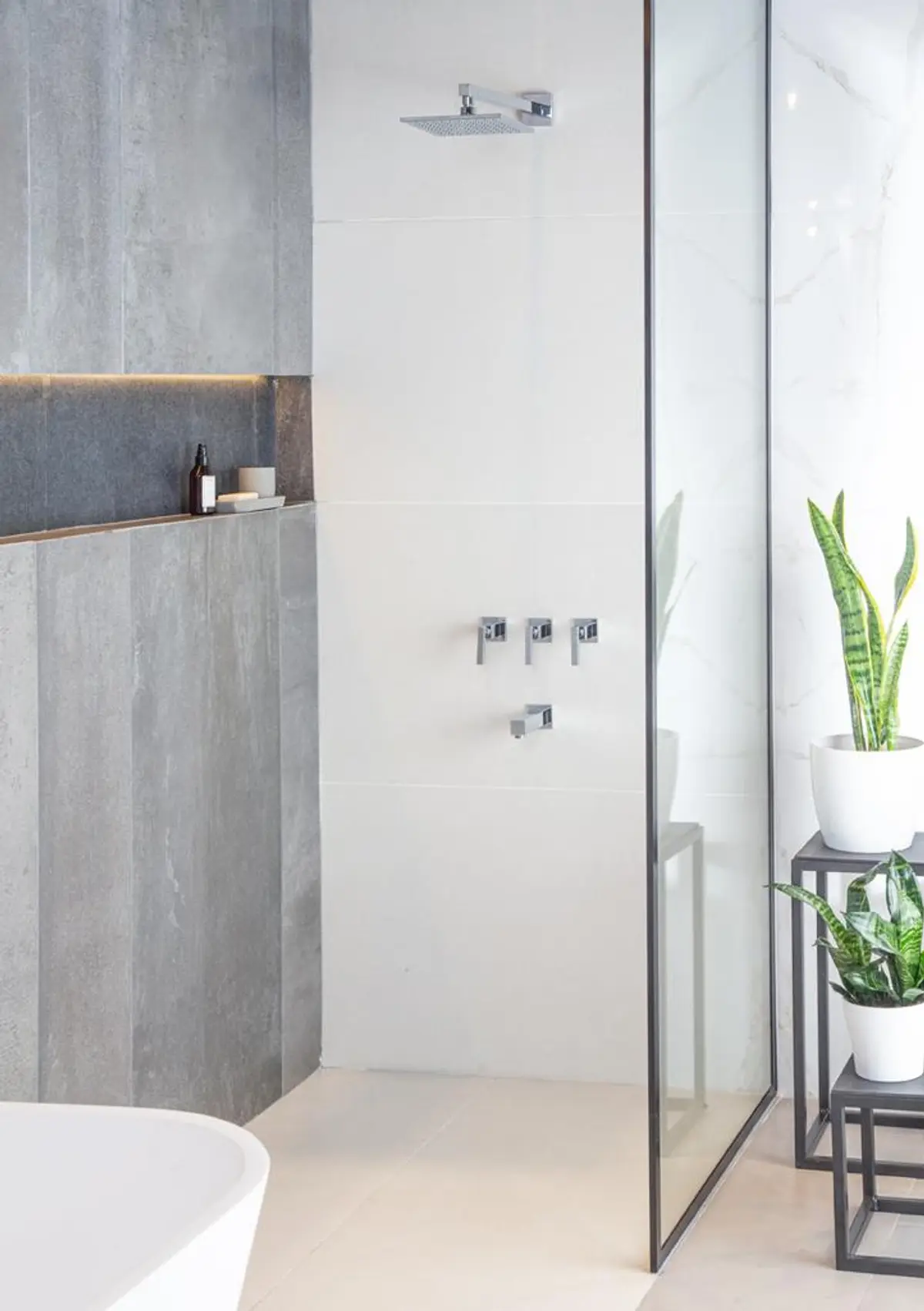 baño moderno con paredes de piedra, ducha y bañera exenta — proyecto Showroom para Vite Porcellanatos (Buenos Aires) German Salas arquitecto, por German Salas arquitectura - San Is