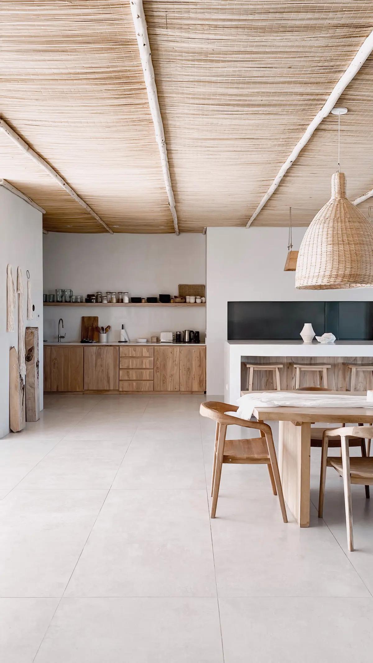 Cozinha e sala de jantar boho-mediterrânea com teto de madeira e lustre de rattan — projeto El Refugio, por Grupo Pauta Arquitectura, em Pinamar