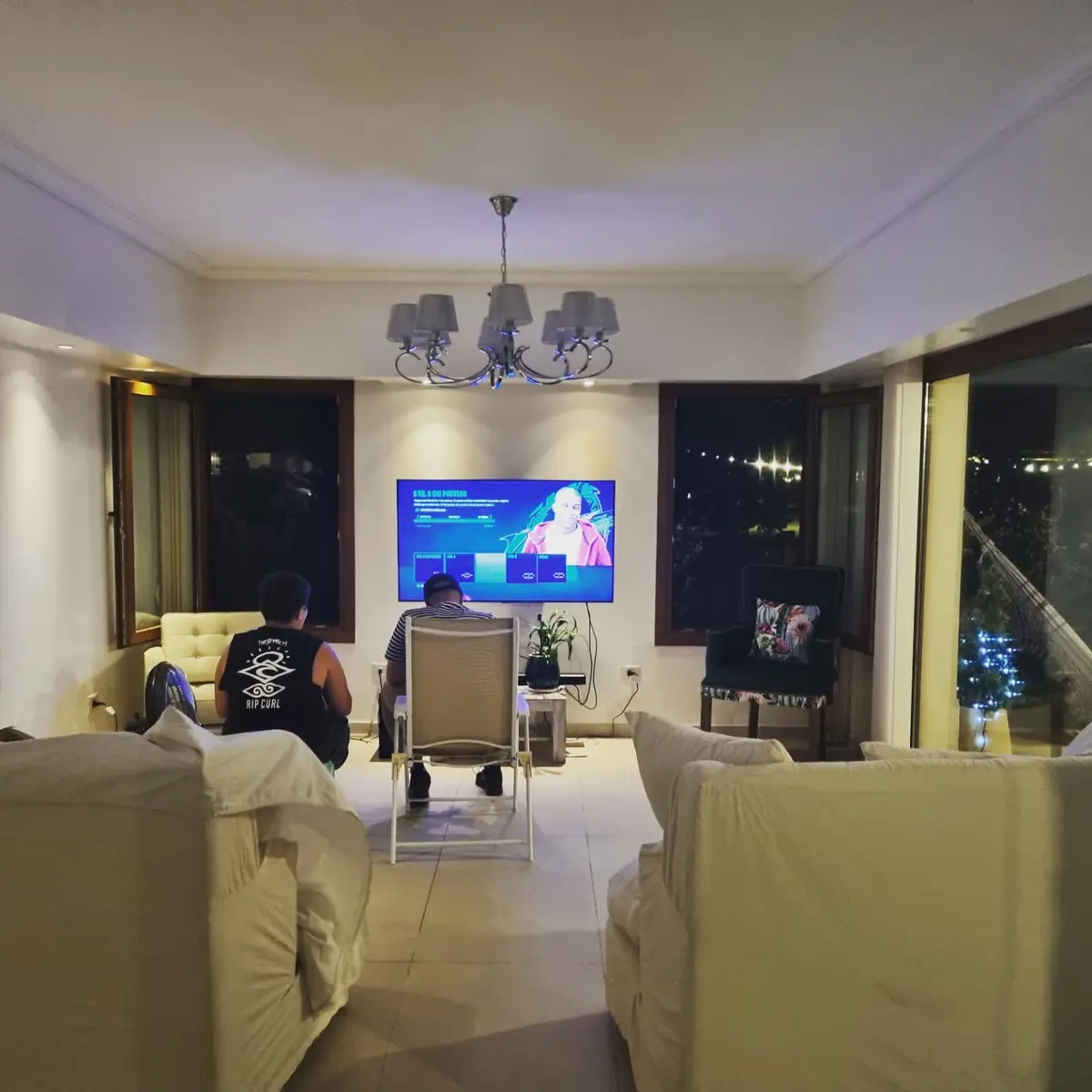 Sala de estar moderna com sofá branco e TV grande — projeto Casa El Rebenque, por Arq. Leonardo  De Lorenzi, em Canning