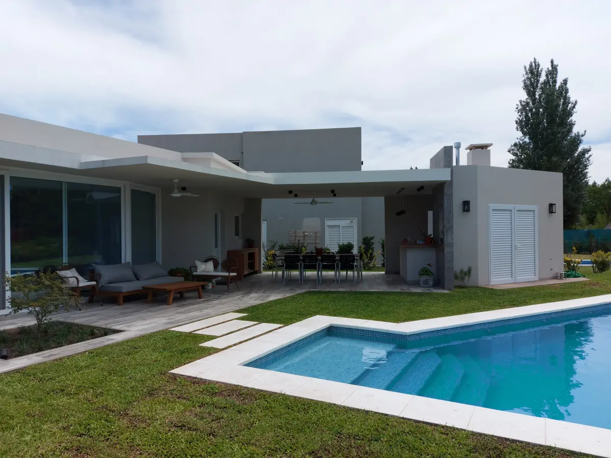 Casa moderna con piscina y pérgola en patio amplio — proyecto Ayres Plaza, por CM Espacio & Arquitectura, en Pilar