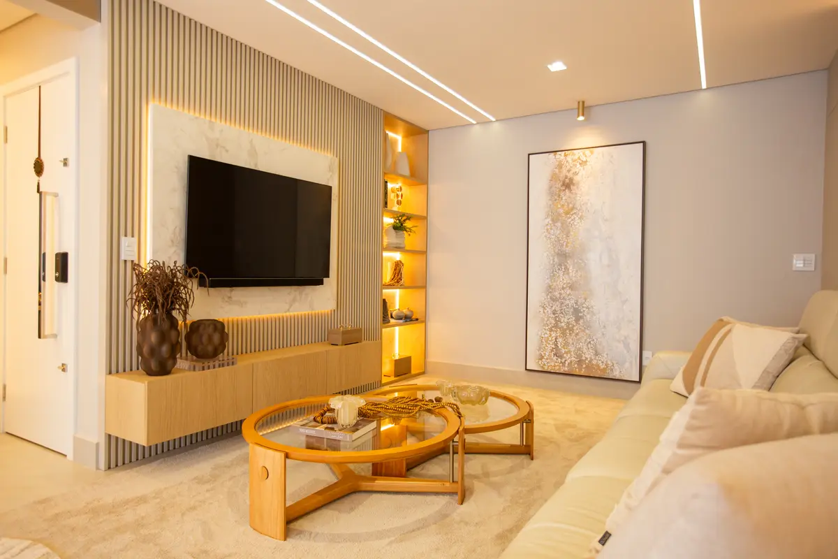 Sala de estar moderna com sofá curvo, arte abstrata e iluminação indireta — projeto Apartamento, por Mariana Cunha Arquitetura, em Curitiba