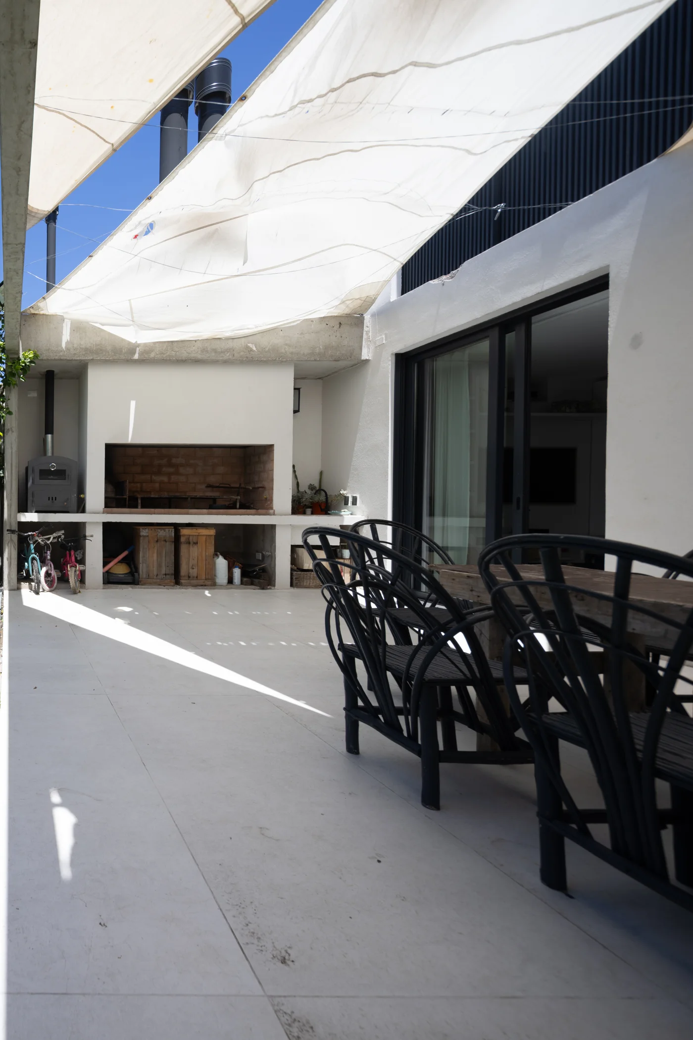 quincho moderno con toldo blanco y sector de parrilla