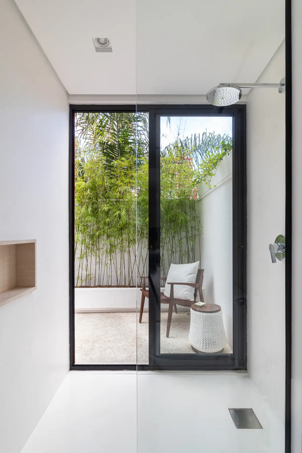 Banheiro moderno com janela para pátio interno com parede verde de bambu — projeto Residencial, por Rodolfo Fontana