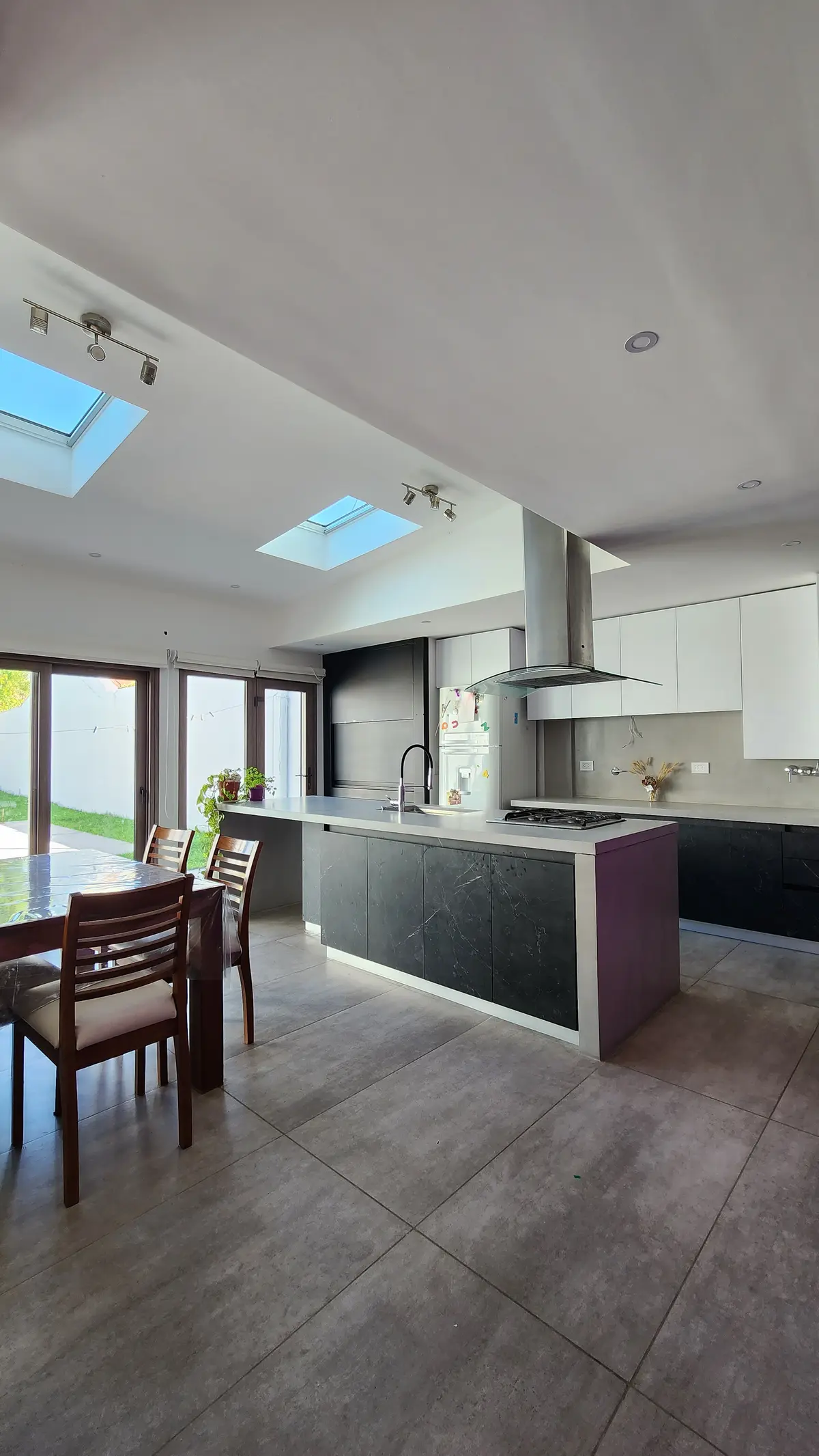 Cocina moderna con isla y comedor, mucha luz natural y tragaluces — proyecto Berner , por ZIMA ARQUITECTURA, en Gonnet