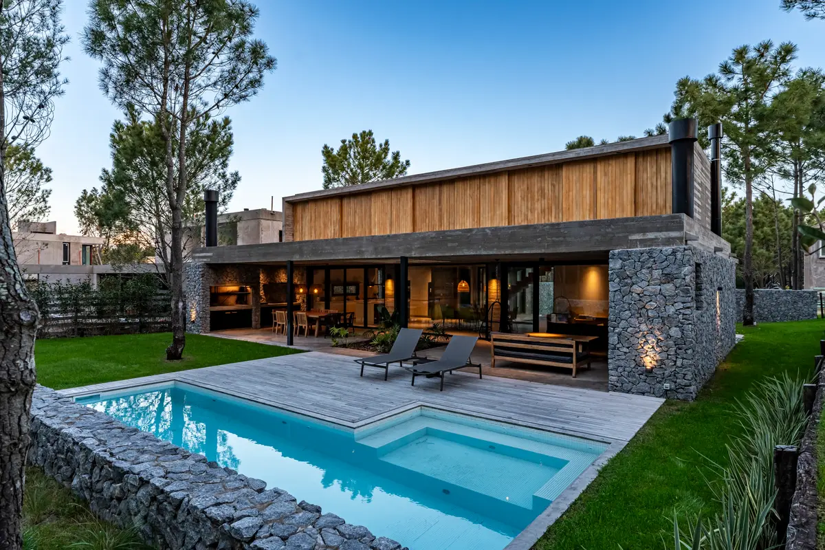 Fachada moderna com piscina e deck de madeira — projeto casa la huella, por Guerrero Arquitectos, em Pinamar