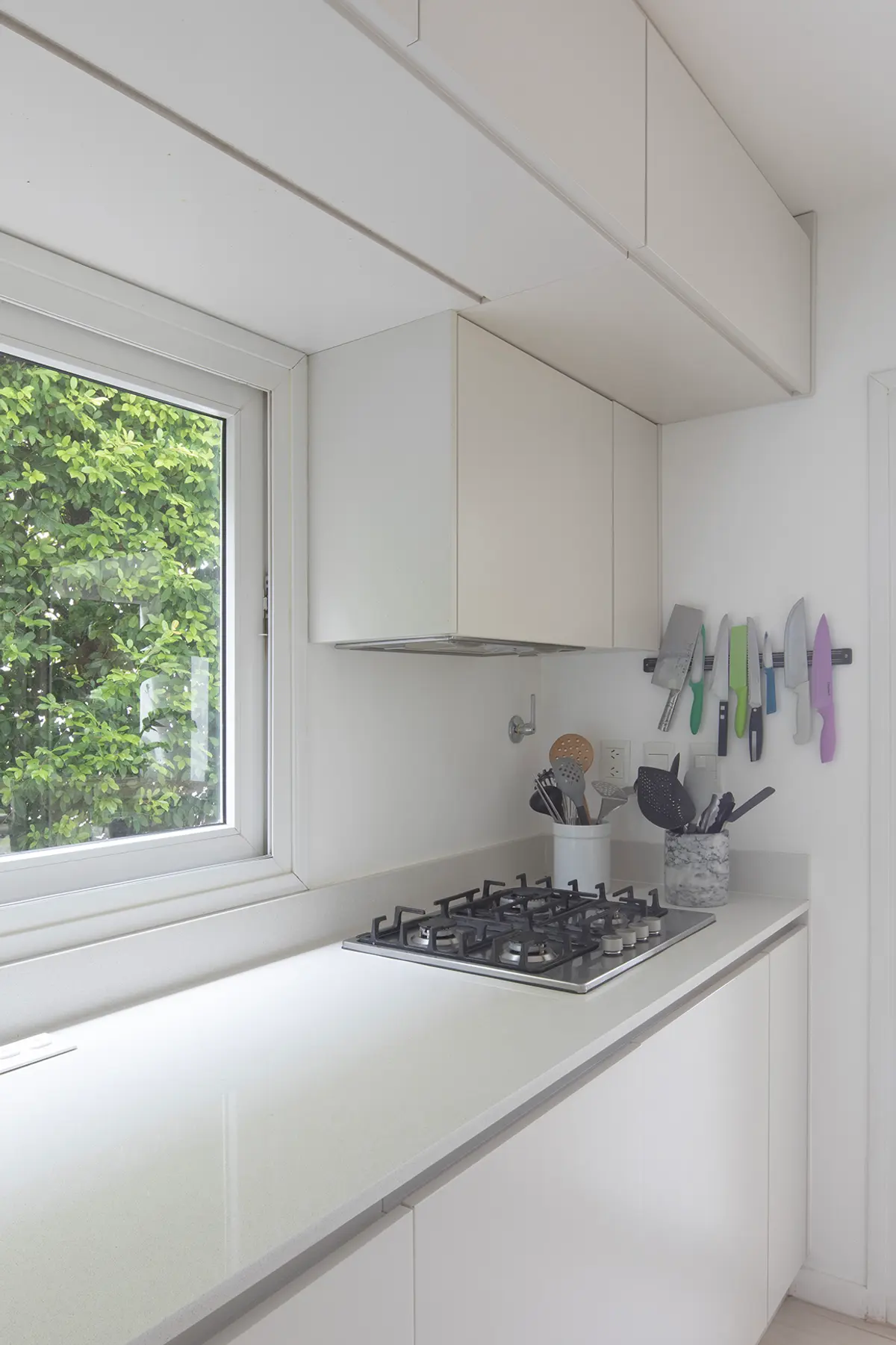 Cozinha moderna branca minimalista com vista para o jardim — projeto Reforma Isla del Sol, por Estudio YME, em Rincón de Milberg