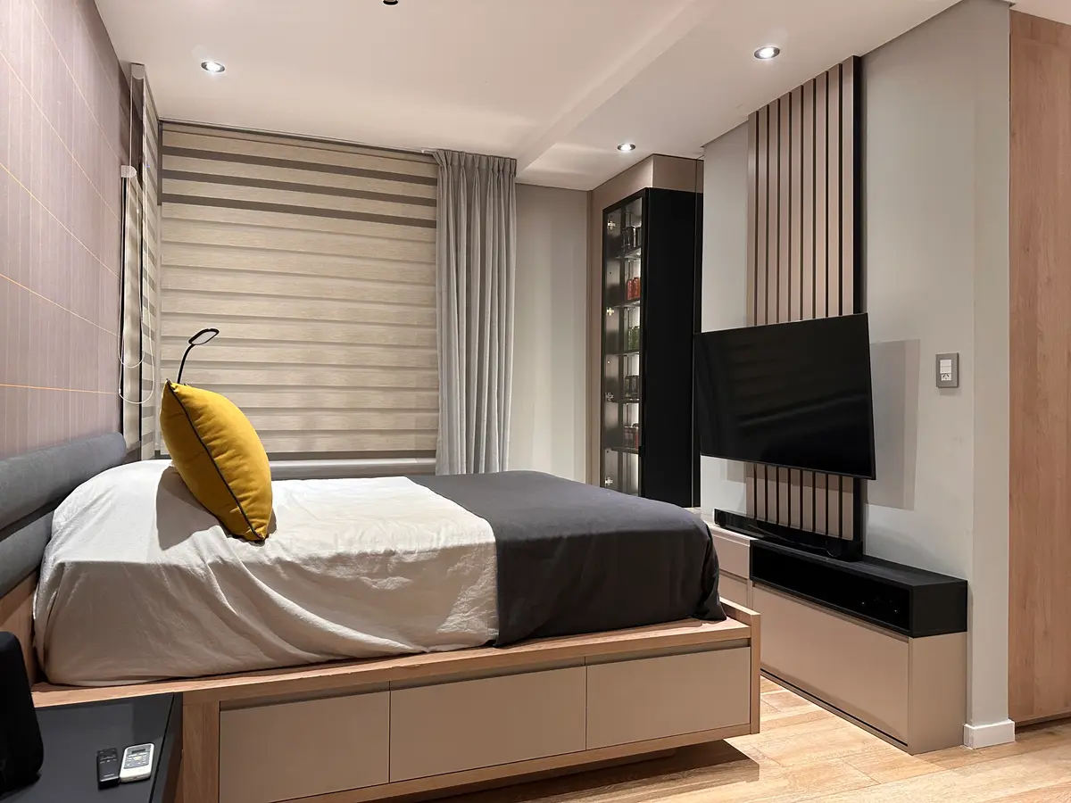 Dormitorio moderno con panelado de madera y almacenamiento integrado — proyecto Proyecto saona, por MÁS studio de diseño, en Buenos Aires