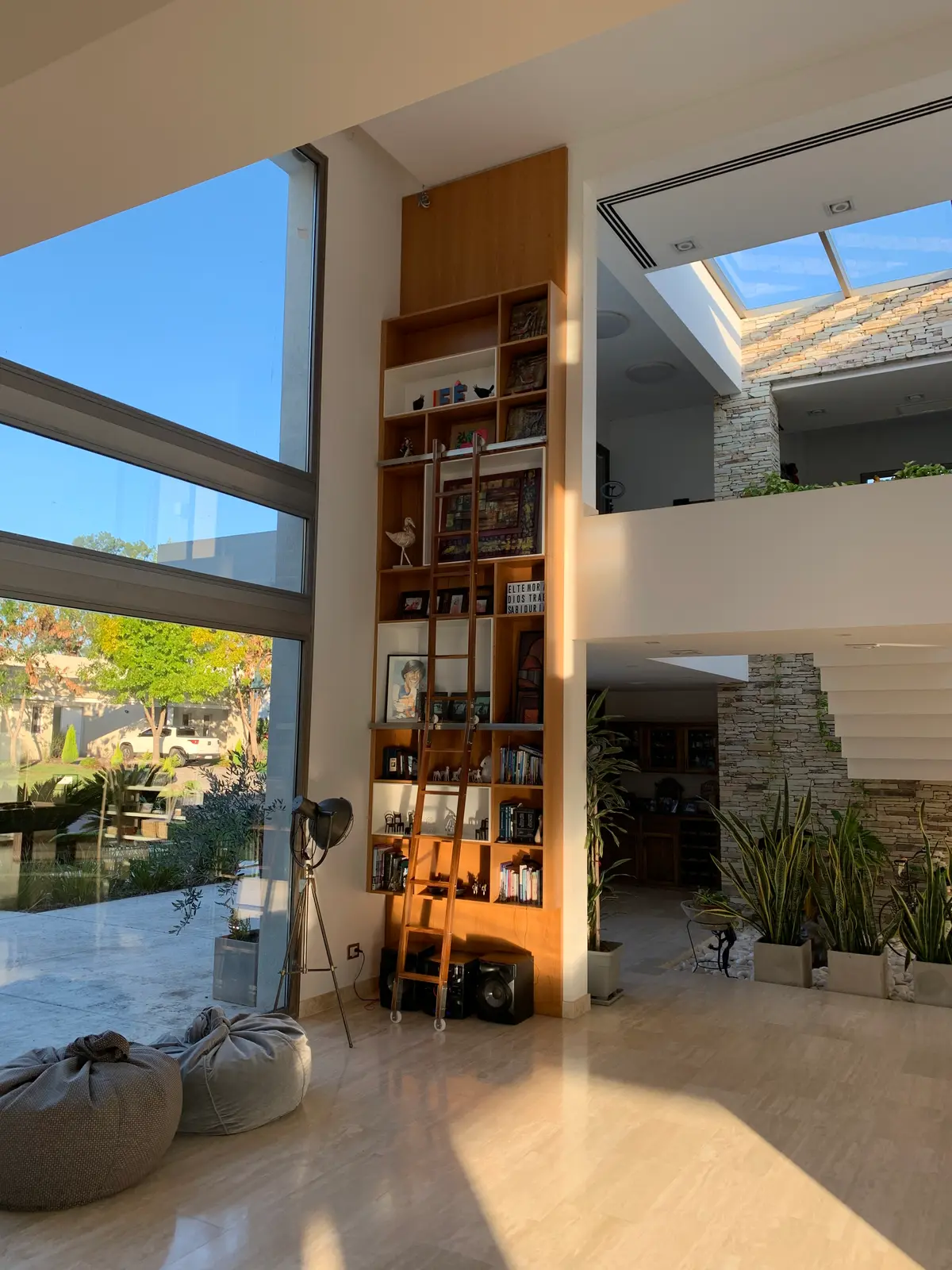 Living comedor moderno y espacioso con ventanales y estantería de madera — proyecto CASA LR 56 - SOFITEL LOS CARDALES  , por Carolina Depetris, en Los Cardales