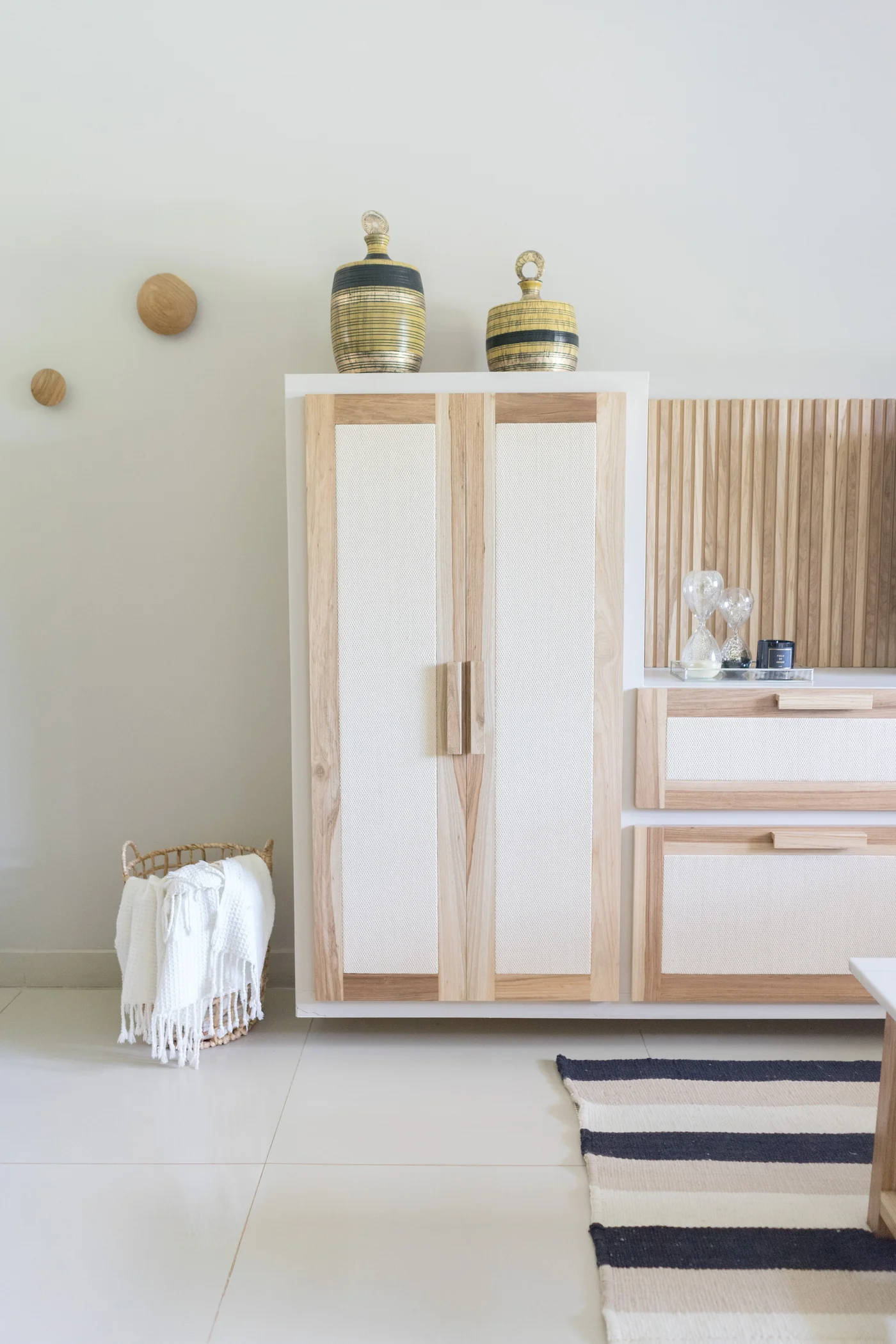 Hall de entrada escandinavo con mueble de madera y cesta de mimbre