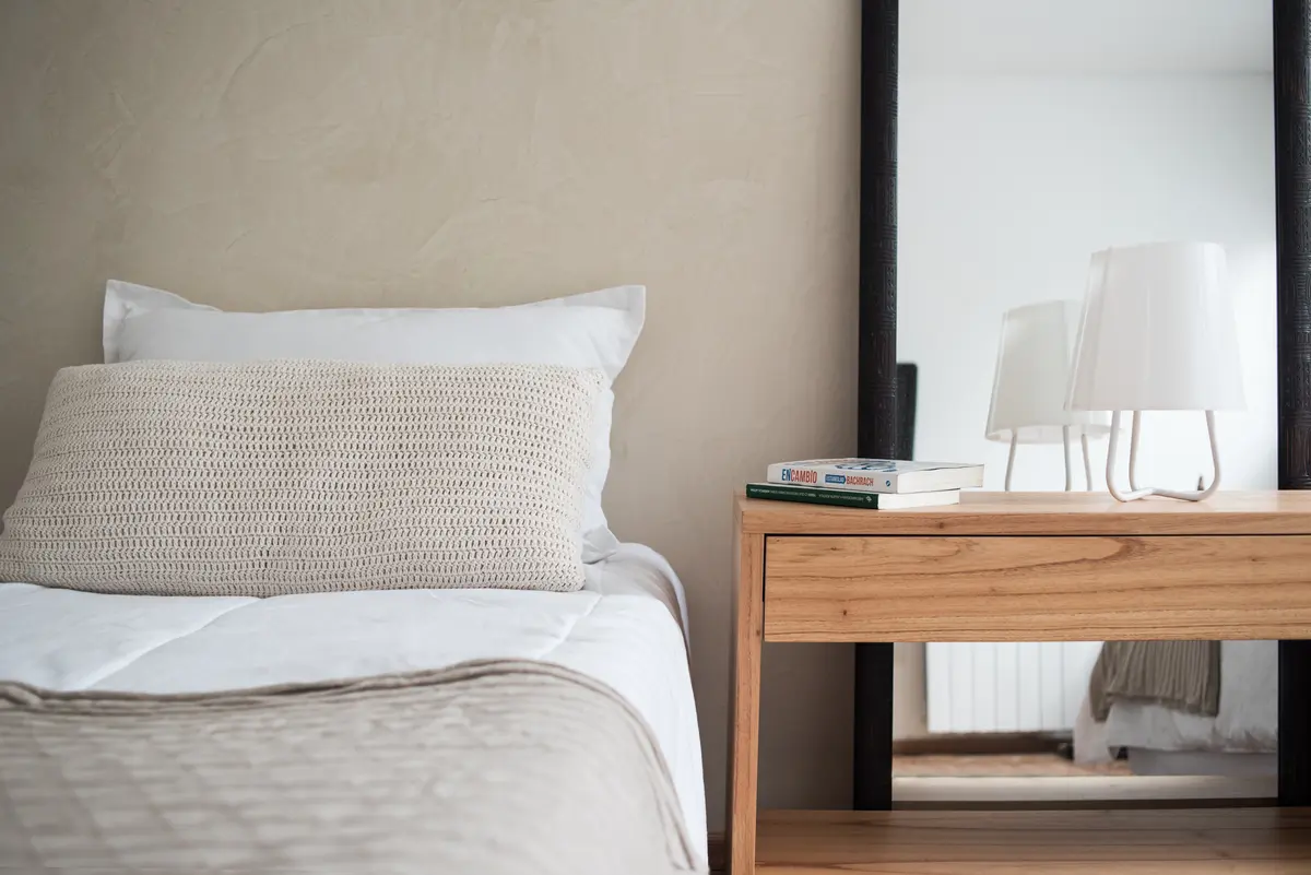Dormitorio minimalista con cama beige y espejo grande — proyecto Ravignani, por Estudio Basa, en Palermo