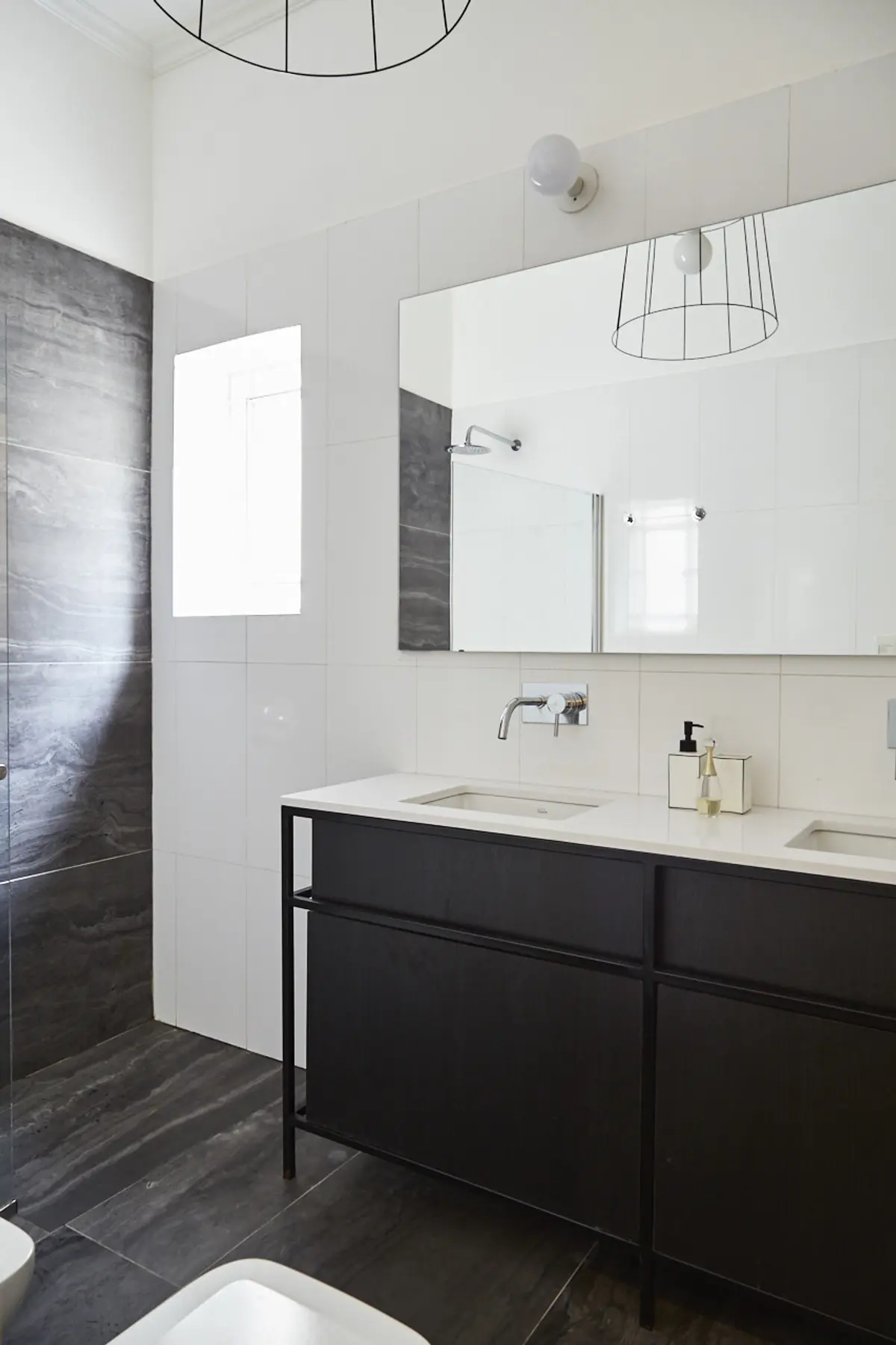Baño moderno con espejo grande y vanitory negro — proyecto BERUTI 2, por Estudio Trama, en Palermo