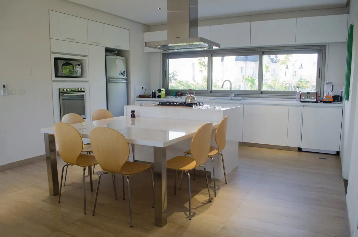 Cocina comedor moderna con isla y amplios ventanales — proyecto Casa Nordelta, por linearecta.arquitectura, en Nordelta