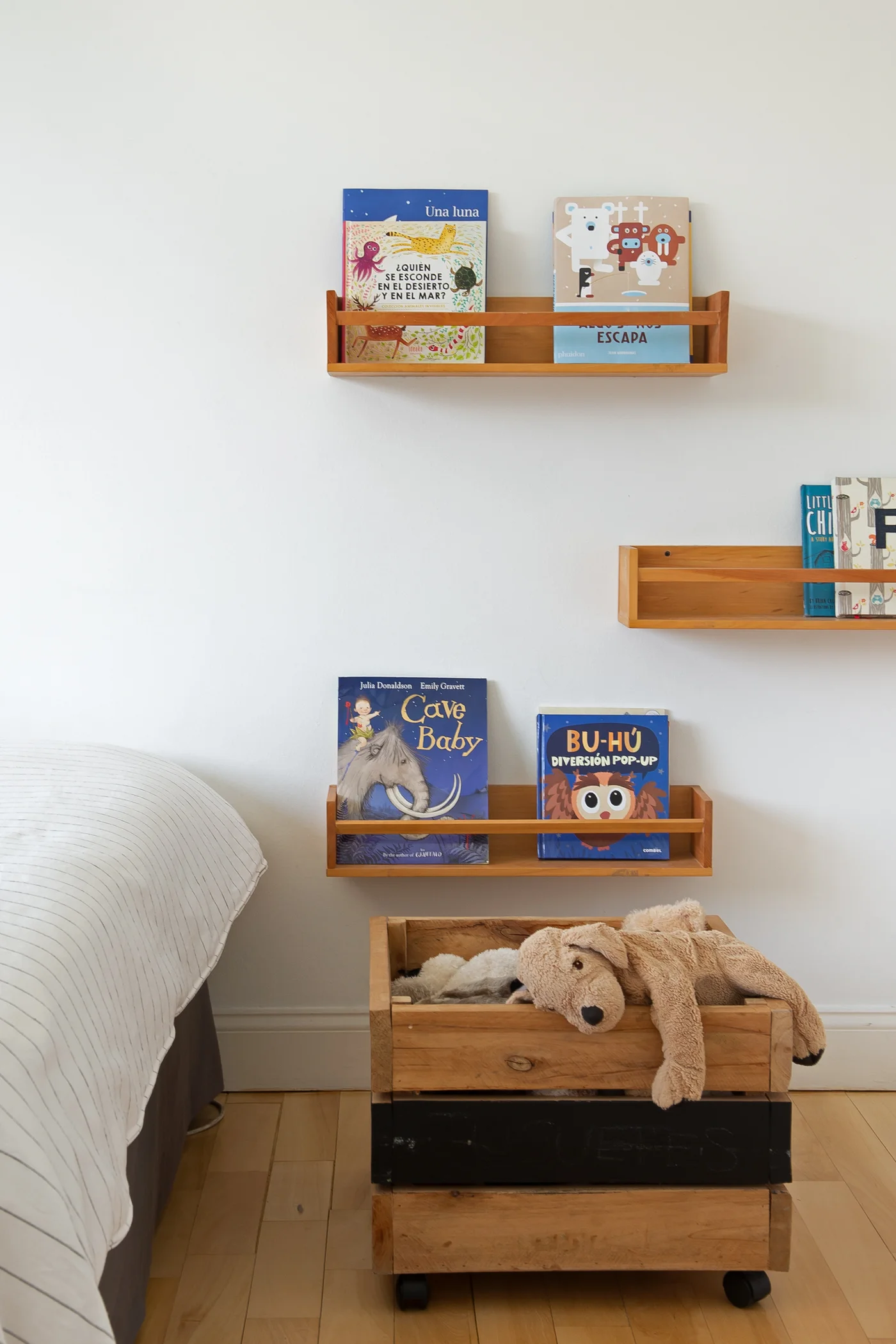 Dormitorio minimalista con estanterías de madera y cama a rayas