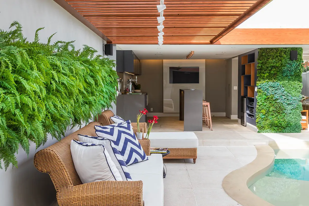 Patio moderno con pileta, jardín vertical y sillón de mimbre — proyecto Casa Barra ED, por Amanda Miranda