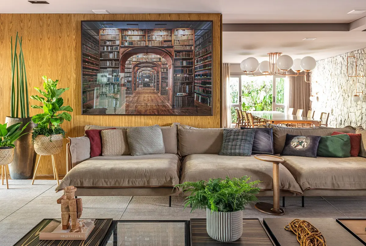 Sala moderna com parede de madeira e quadro grande de livraria — projeto Casa Da Re, por Estúdio Shirlei Proença