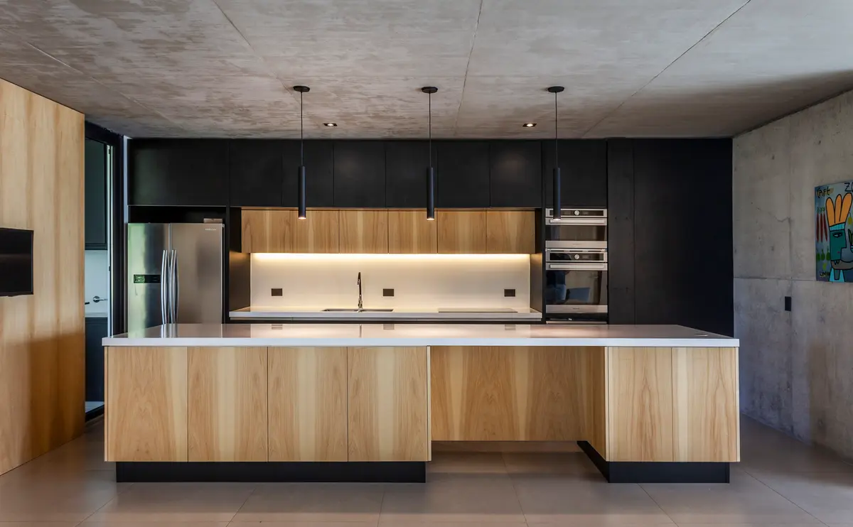 Cocina moderna con isla de madera y techo de hormigón — proyecto Casa ALVA, por V2 Arquitectos, en City Bell