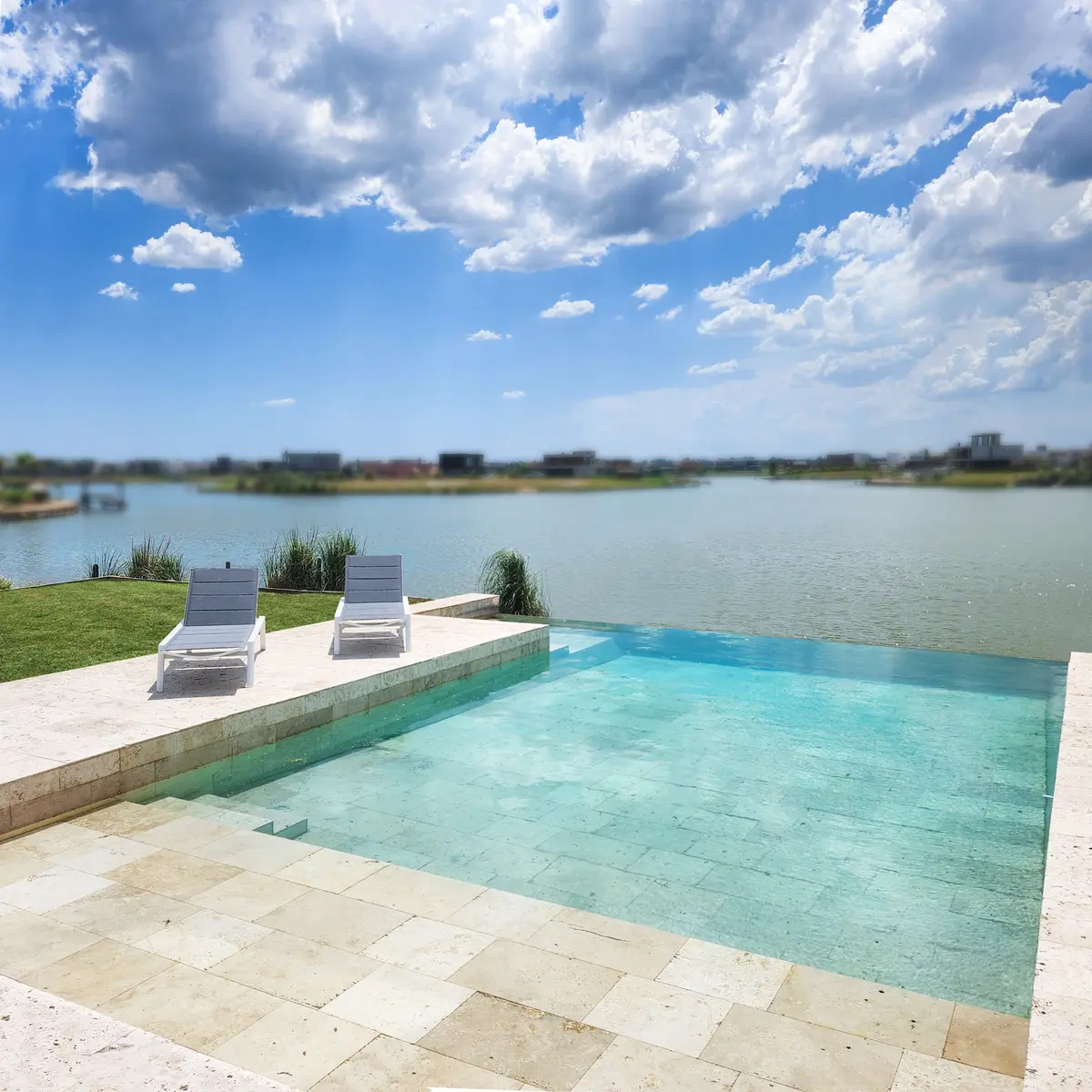 Piscina moderna con deck de piedra y vista al agua — proyecto Casa SS, por Hernan Goldfarb, en Pilar