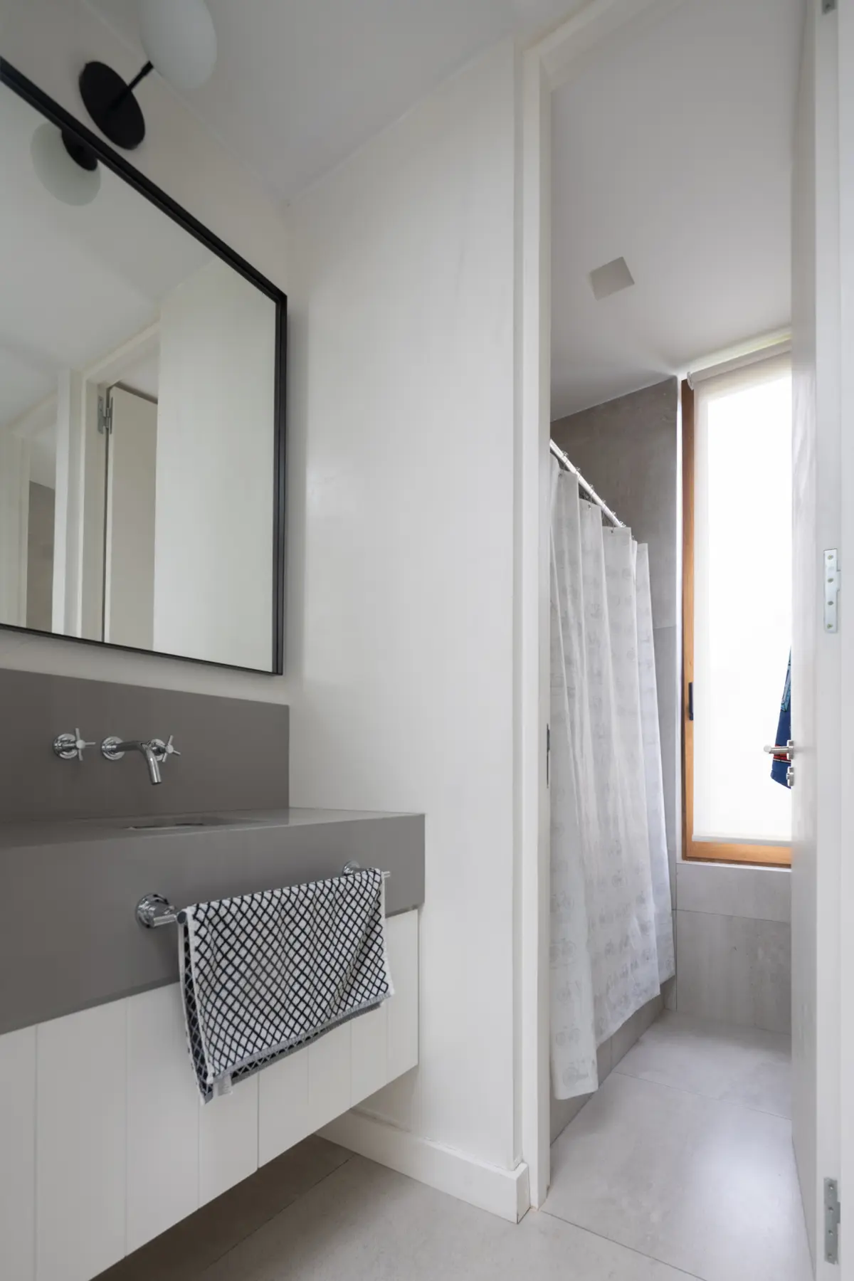 Baño moderno minimalista con vanitory de hormigón y espejo grande — proyecto CASA OrAz, por Alfredo Orfila arquitectura, en San Isidro