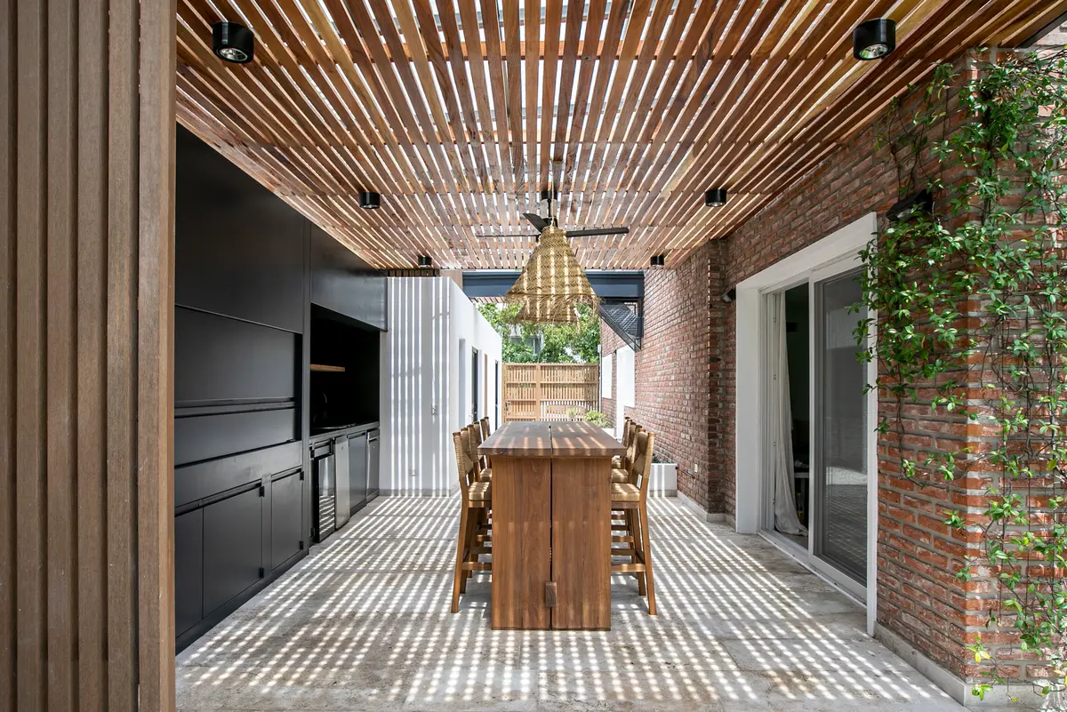 Comedor exterior con techo de madera y ladrillo expuesto — proyecto Obra La Posta, por Arq. Lourdes Yarade Saravia, en Pilar