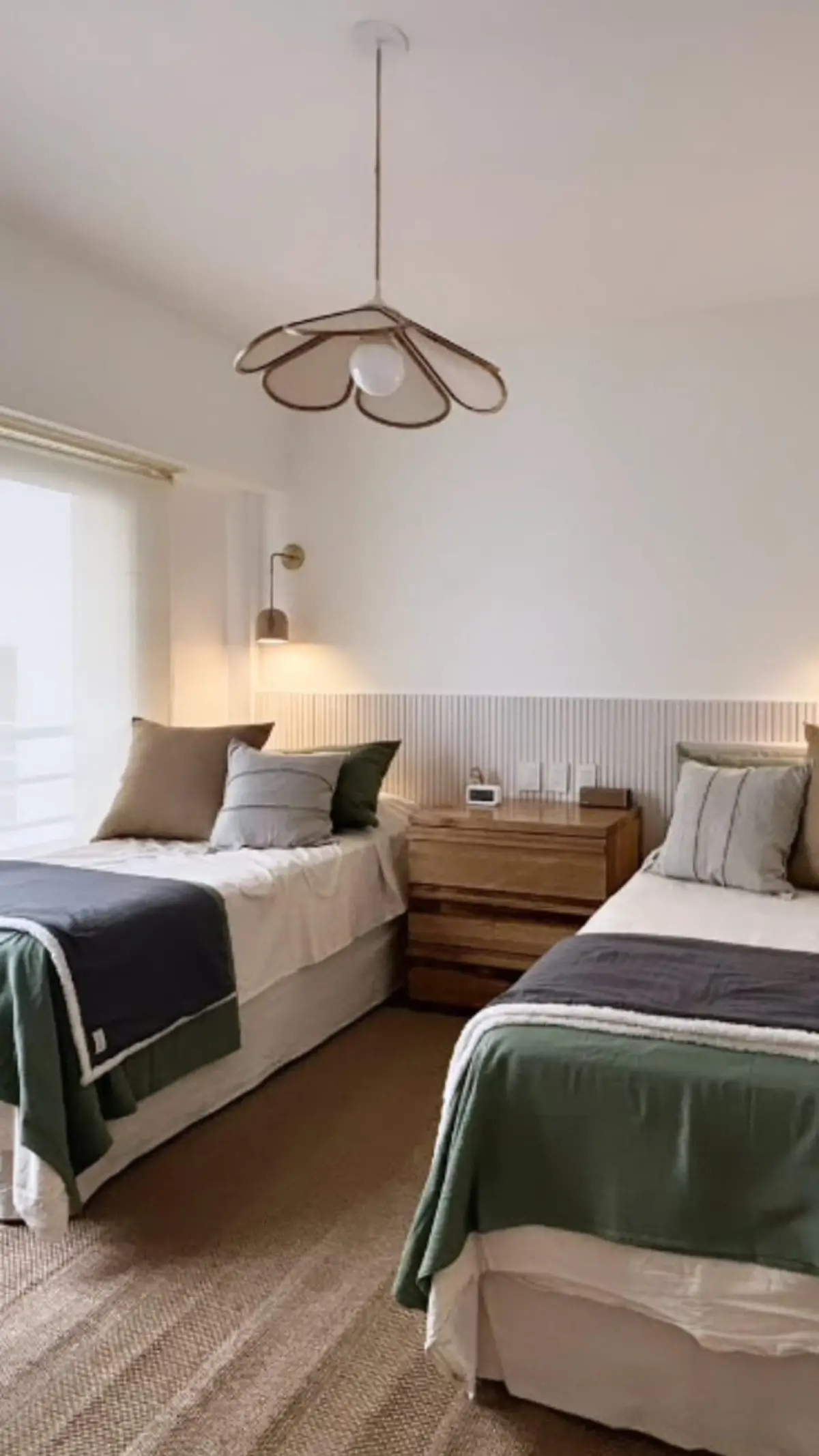 Quarto moderno com duas camas, lustre floral e detalhes em madeira — projeto Uruguay, por Claraboia, em Recoleta