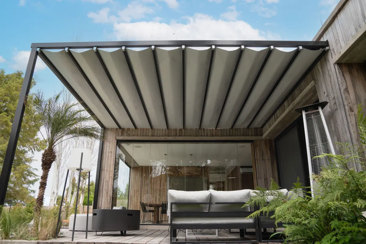 Pátio moderno com pérgola retrátil e sofás cinzas — projeto TOLDER - PERGOLAS, por Argentina en Obra 2024, em Rincón de Milberg