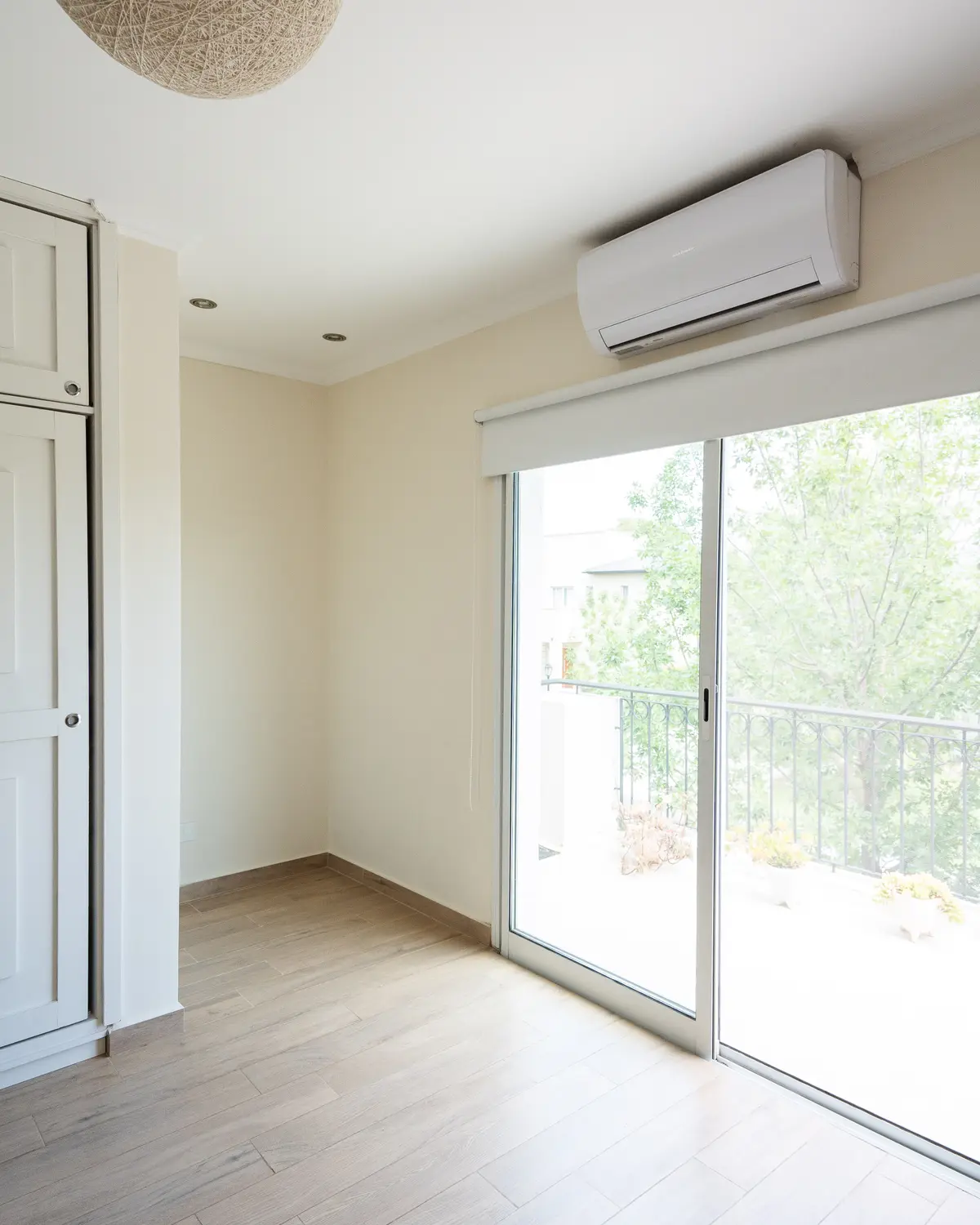 Dormitorio minimalista con puerta balcón y aire acondicionado — proyecto Proyecto Pilar, por Blue Rabbit Design, en Pilar