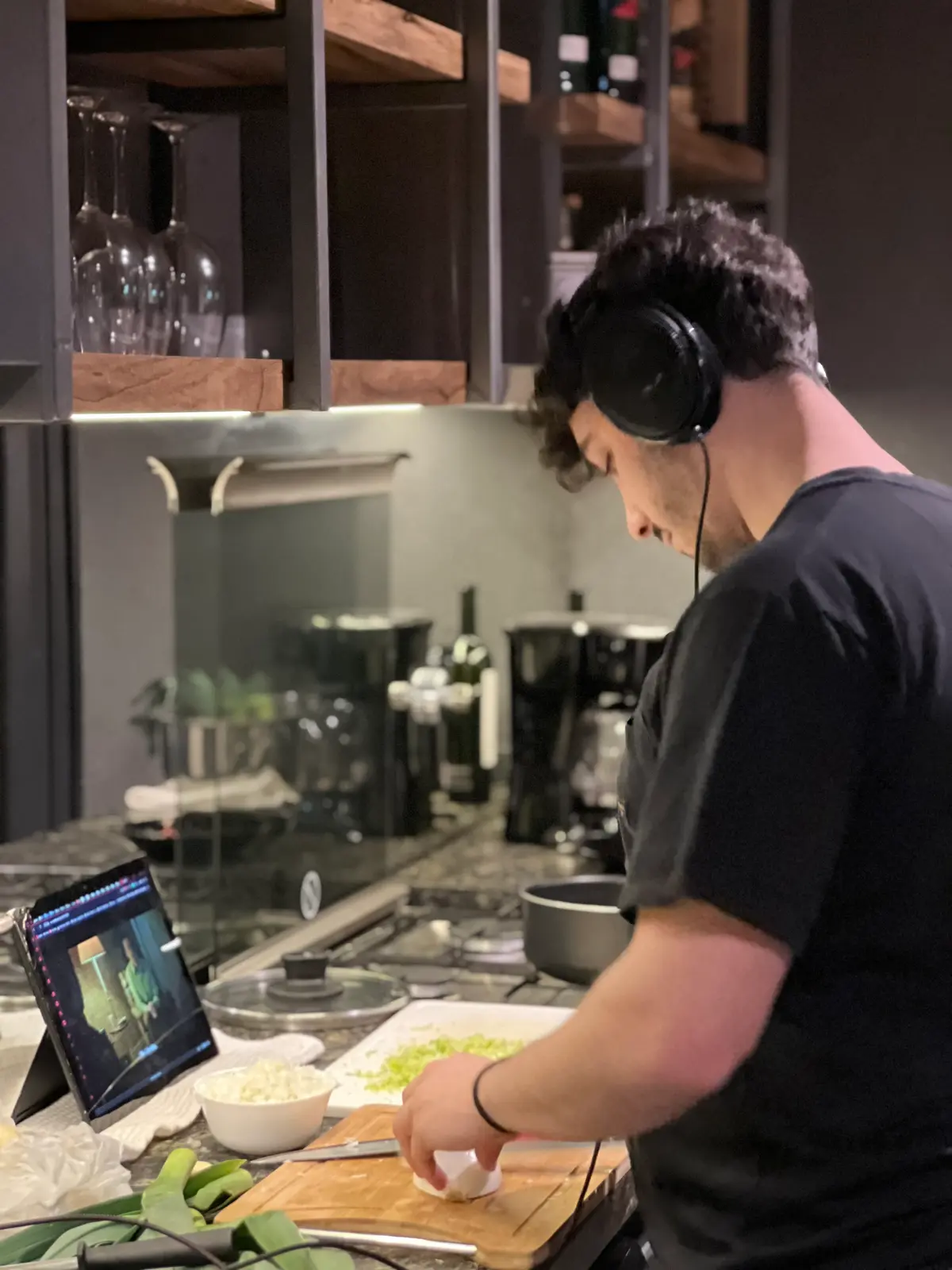 Cozinha moderna industrial com pessoa cozinhando de fones de ouvido — projeto Casa CE, por Estudio FORSCH, em Pinamar