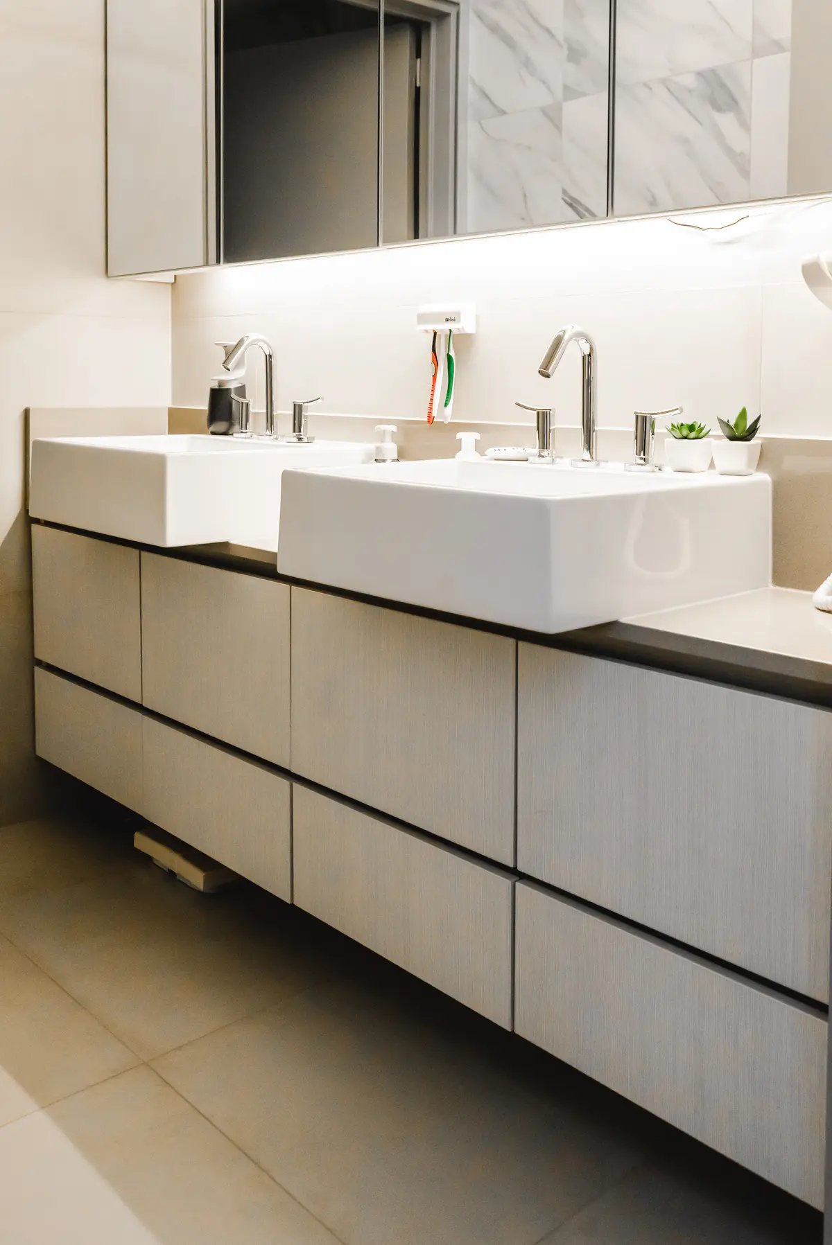 Bano minimalista con doble vanitory blanco y espejo marmolado — proyecto Cabrera, por Tali Estudio, en Palermo