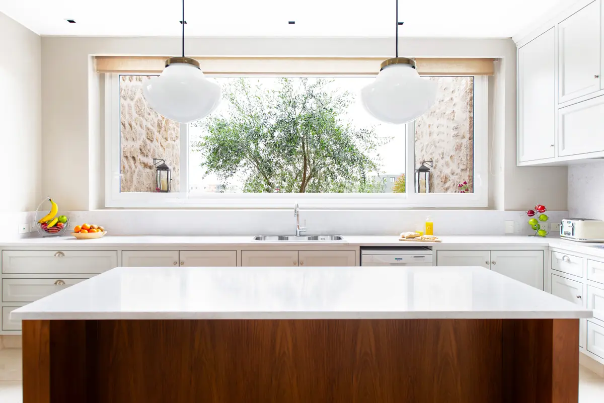 Cocina moderna con isla y gran ventana al exterior — proyecto Casa MF, por Estudio Junor, en Belén de Escobar