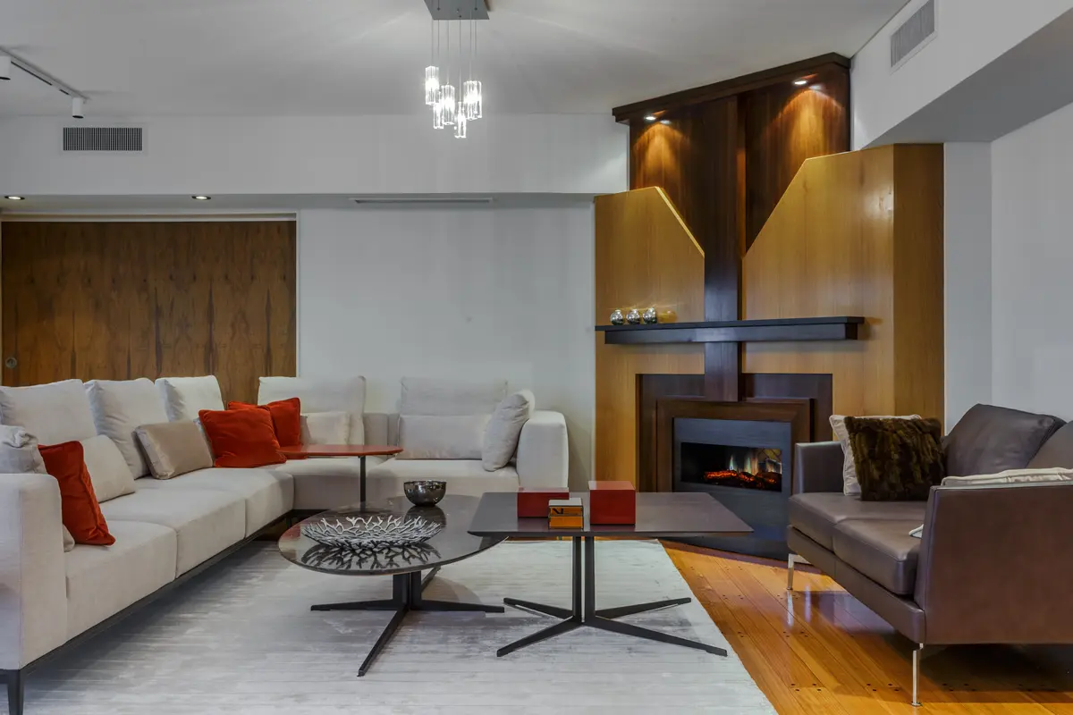 Sala de estar moderna com lareira, sofá e mesa de centro — projeto Piso en Belgrano III, por Gutman+Lehrer Arquitectas, em Belgrano