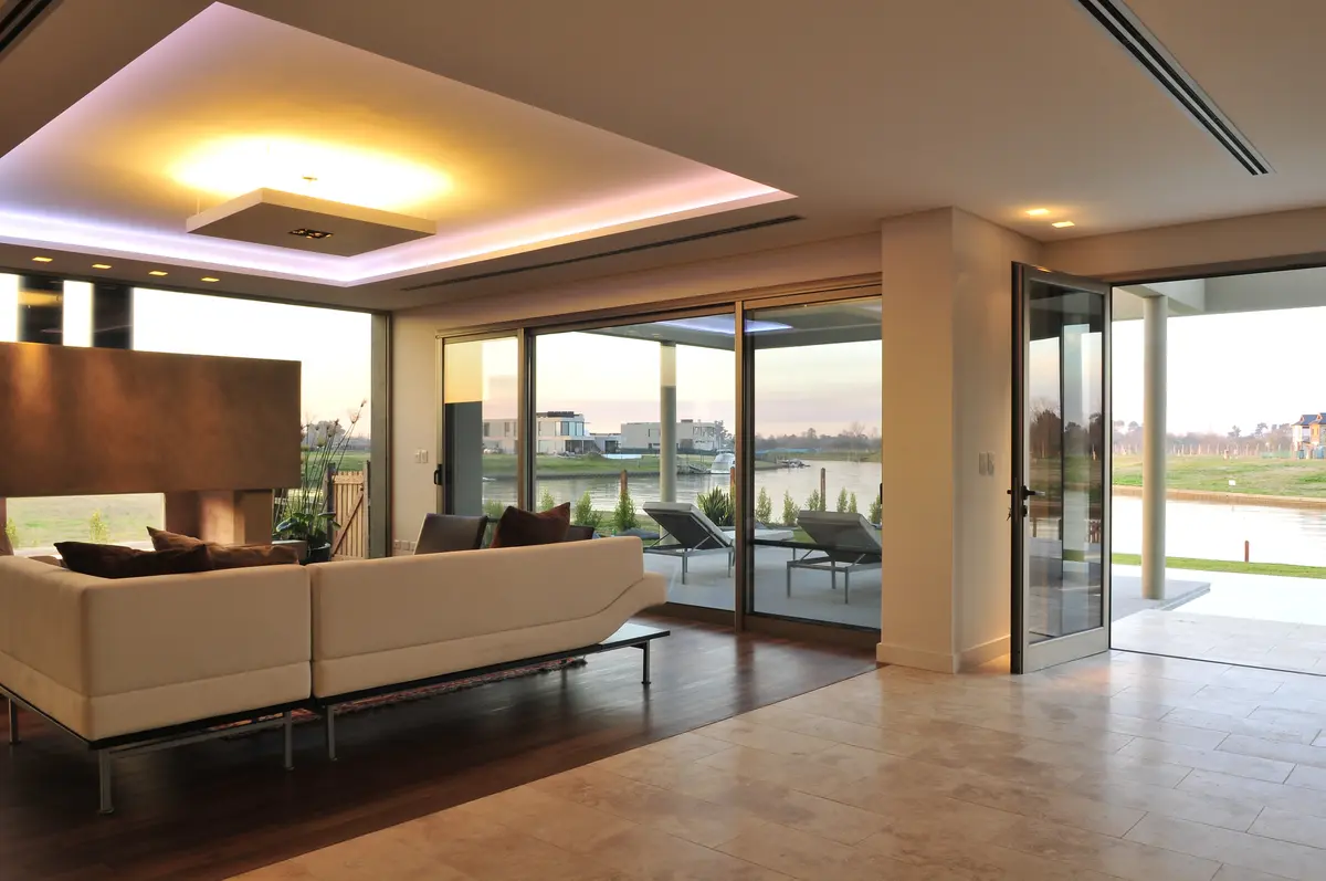 Living comedor moderno con vista al agua y grandes ventanales — proyecto Moderna Seducción, por Apaarquitectura, en Tigre