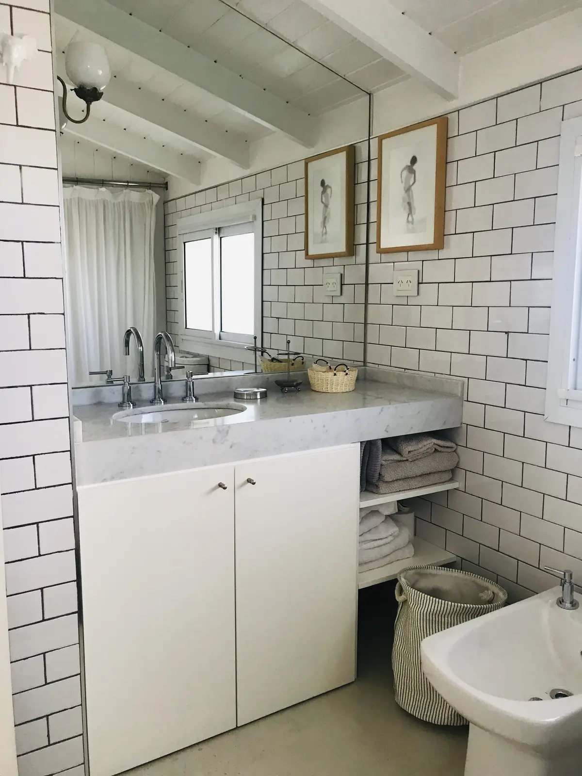 Baño moderno con azulejos subway, vanitory de mármol y vigas de madera — proyecto Monroe - La Horqueta, por Mgc.arq, en La Horqueta