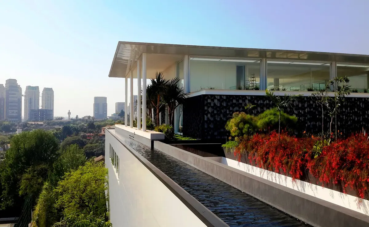 Terraza moderna con vistas a ciudad, jardín vertical y piscina integrada — proyecto Residência HC, por Gil Fialho