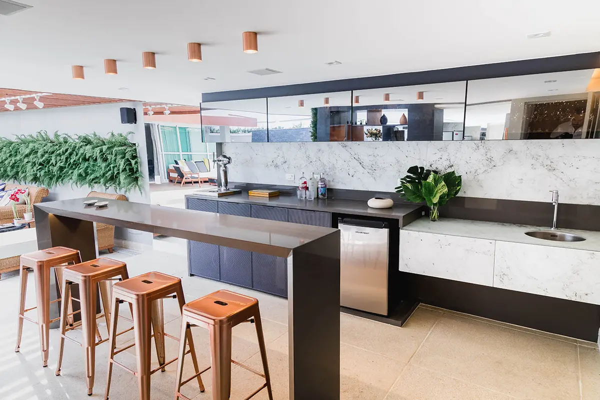 Cocina moderna con isla central, mesadas de mármol y vista al patio — proyecto Casa Barra ED, por Amanda Miranda