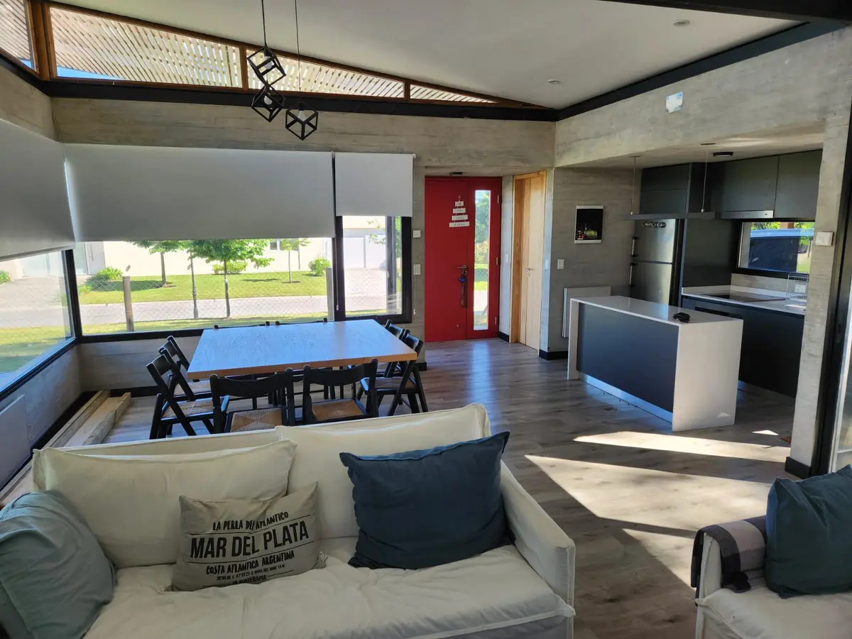 Sala de estar e jantar moderna industrial com concreto aparente e janelas amplas — projeto Casa Arenas del Sur, por Arq Fernando Ossvald, em Mar del Plata