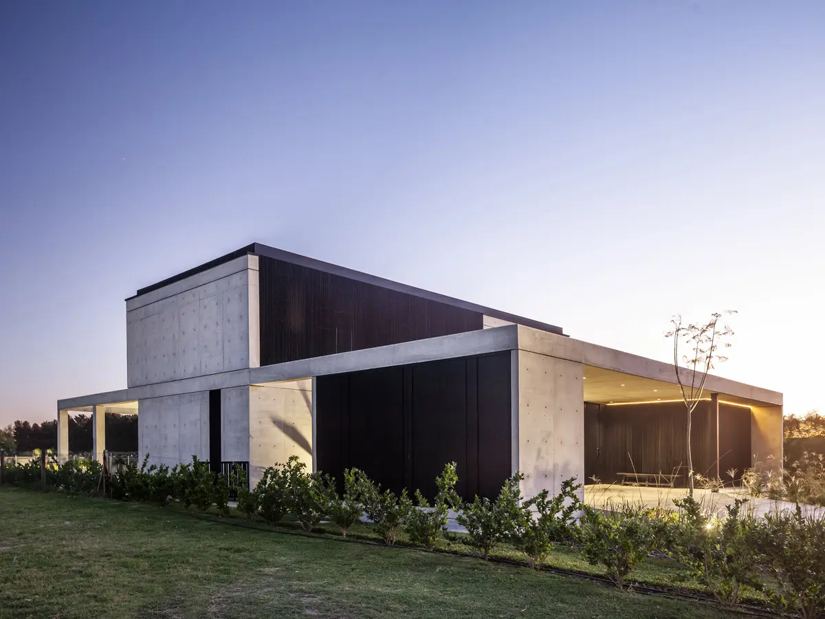 casa moderna brutalista con hormigón y madera en entorno rural — proyecto CASA FELIX, por GMARQ, en Pilar
