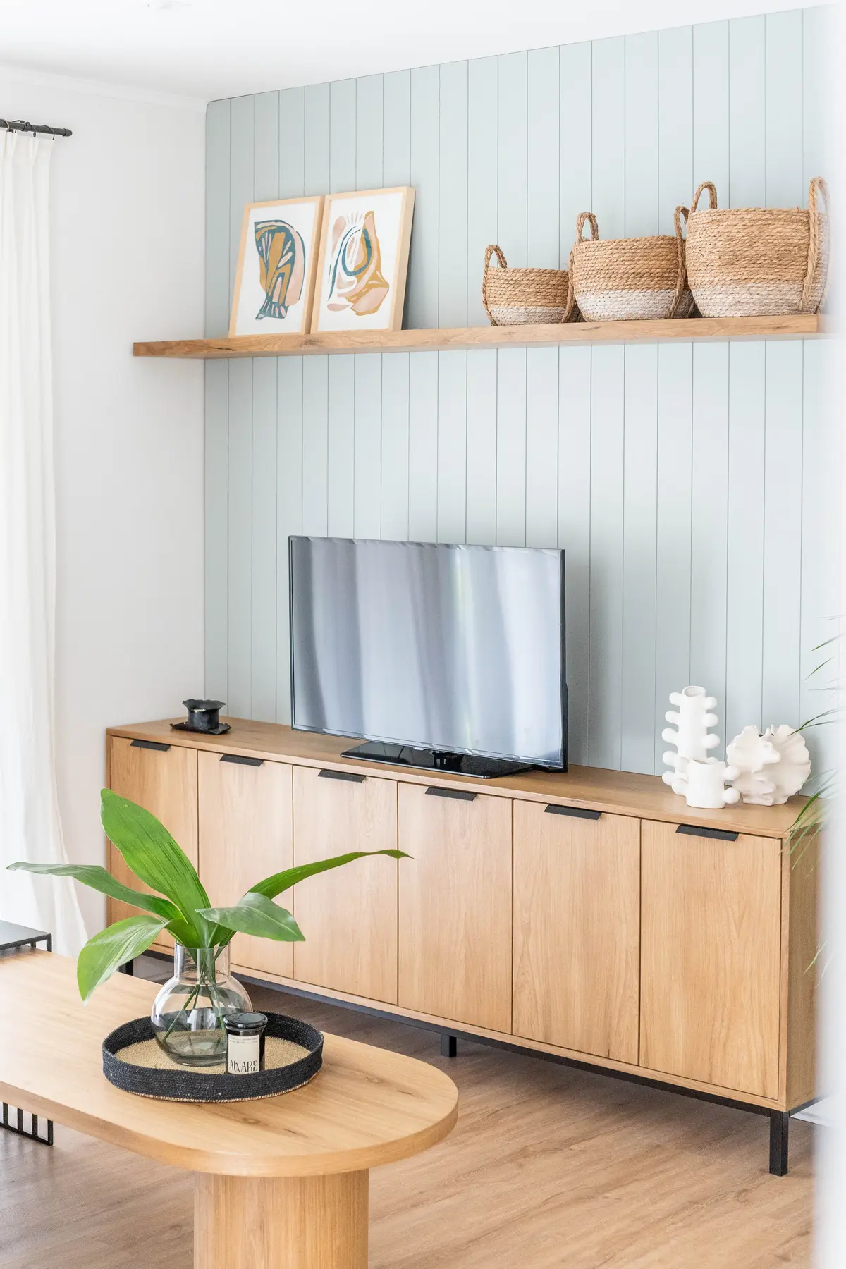Sala de estar escandinava com painel azul e móvel de carvalho — projeto El Atardecer - Estar, por Blue Rabbit Design, em Rincón de Milberg