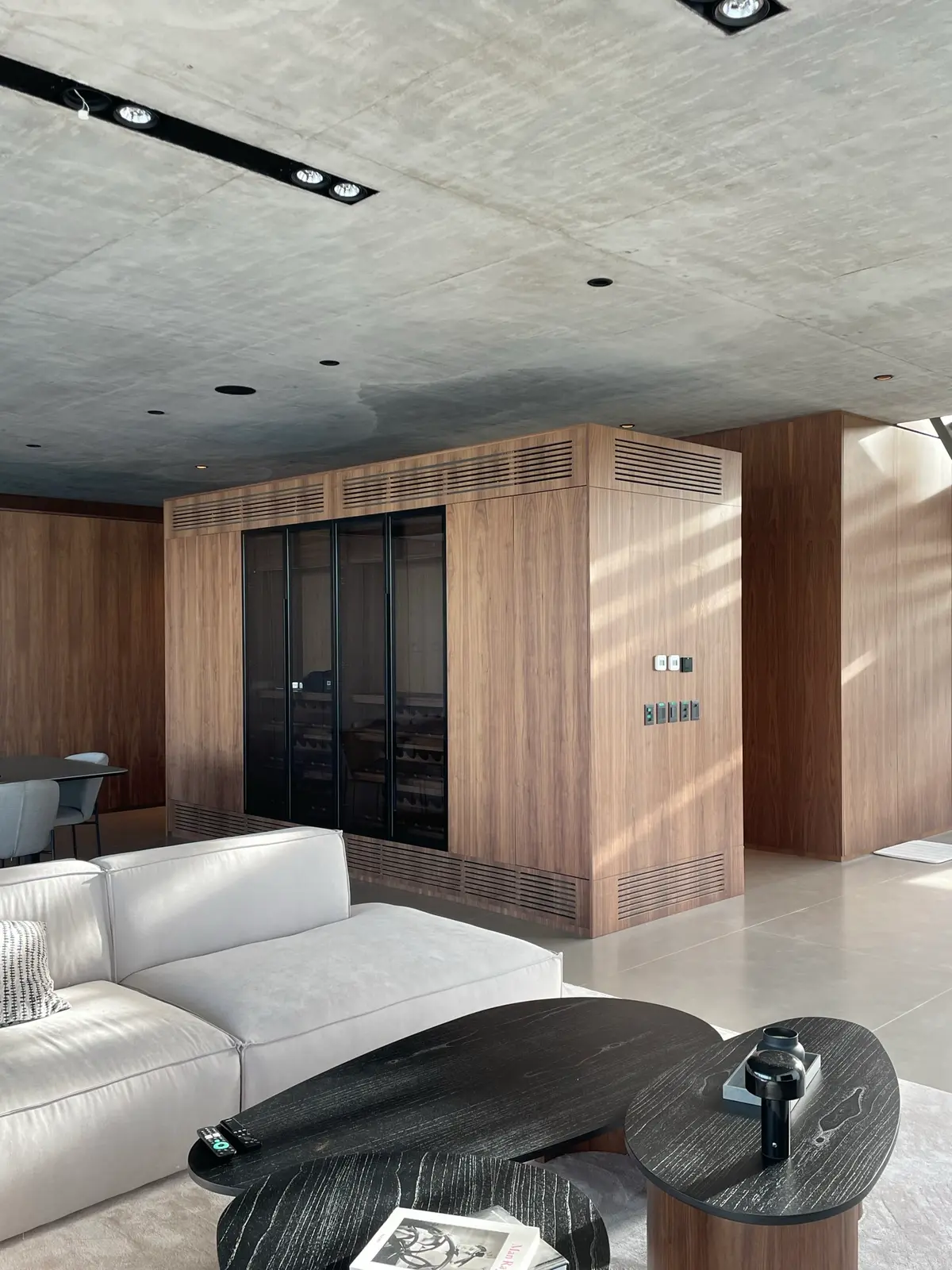 Sala de estar moderna com teto de concreto e painéis de madeira — projeto Albanueva - Estudio Amado Cattaneo, por ABEJA CONCEPT, em Nordelta