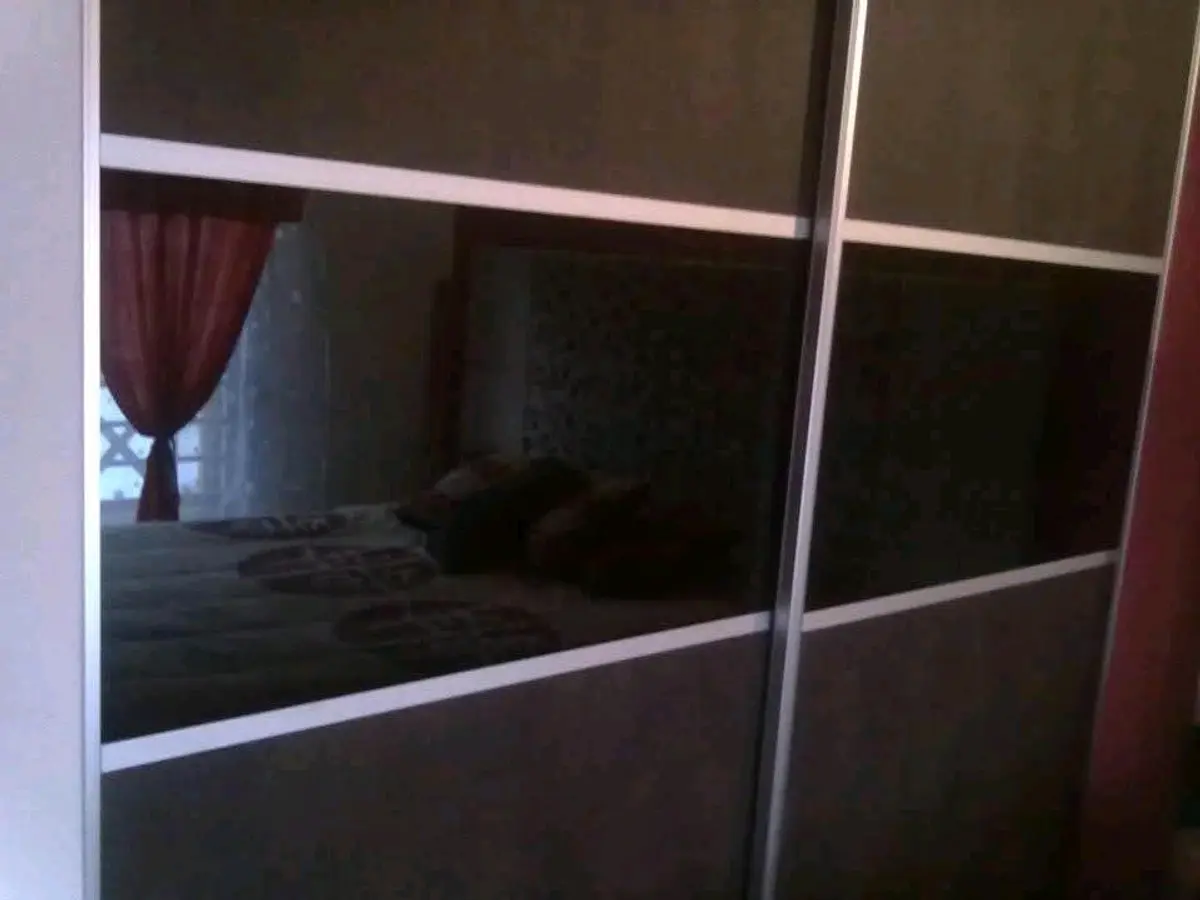 dormitorio con placard espejado y cortinas de terciopelo rojo — proyecto Interiores de placares y frentes de placares diseños exclusivos, por Tientta Carpinteria de diseño, en Cann