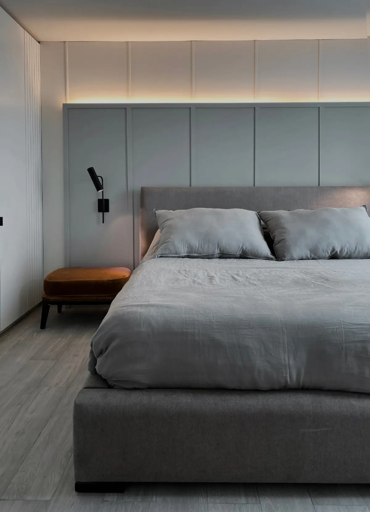 Dormitorio minimalista con iluminación indirecta y paneles de pared texturizados — proyecto Pampa, por ABEJA CONCEPT, en Belgrano