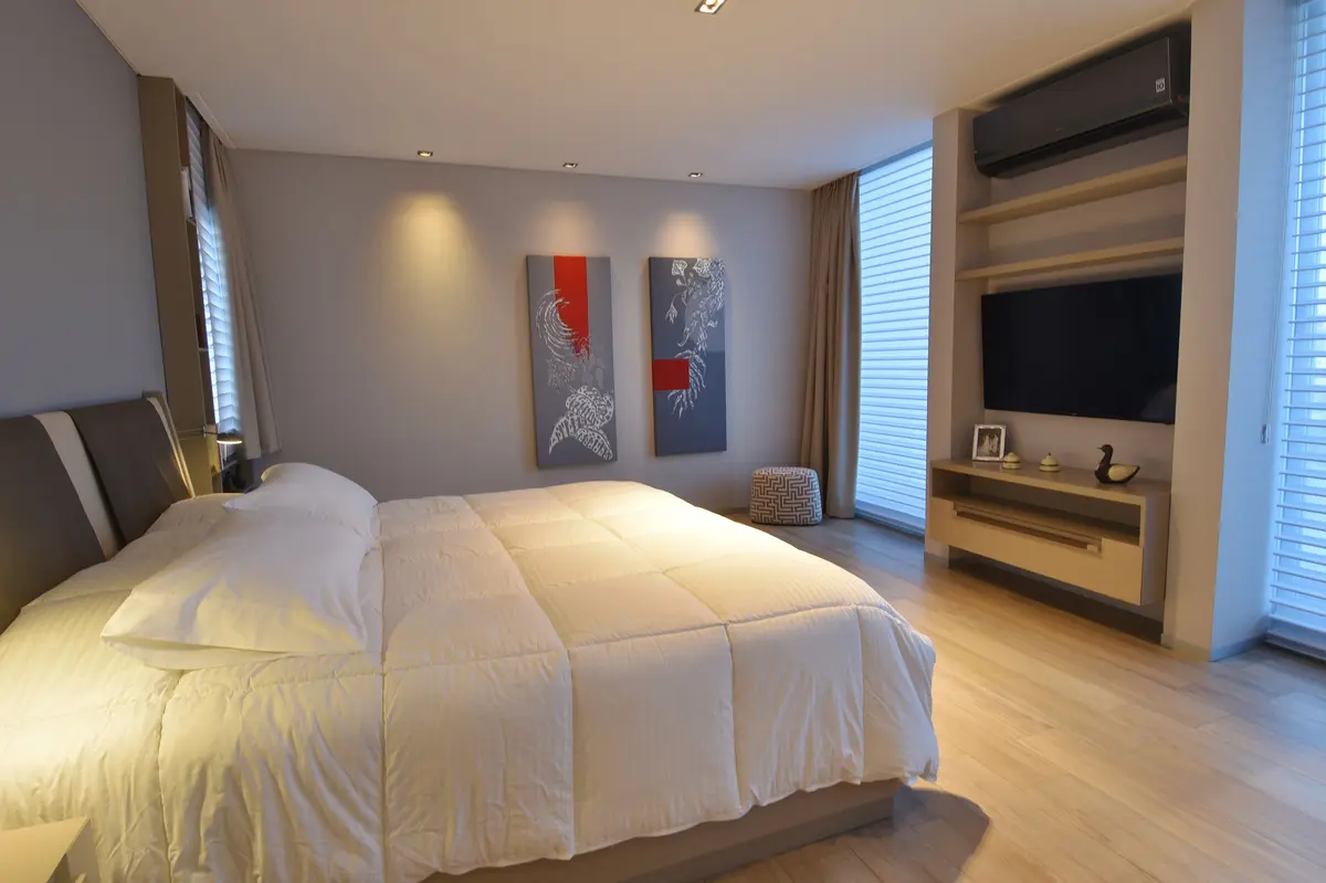 Dormitorio moderno con cama blanca y estanterías empotradas — proyecto Casa JSR, por Santiago Cordeyro Arquitectos, en Tigre