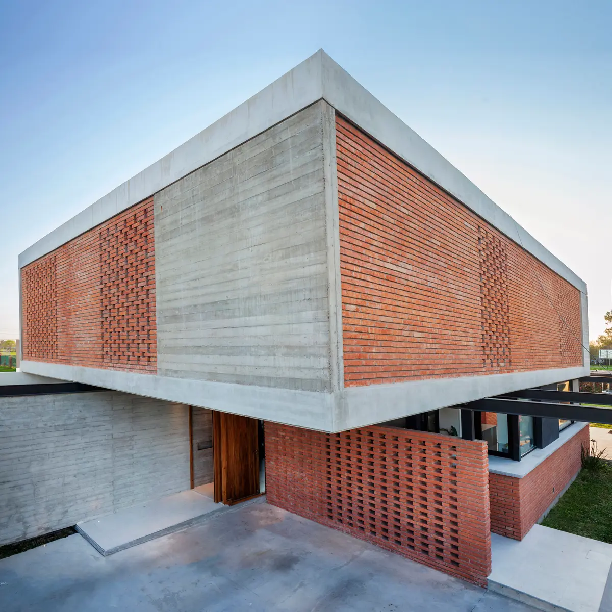 Fachada moderna brutalista com tijolo perfurado e concreto — projeto CASA BSB, por BUSCETTI & DI BERNARDO arquitectas, em Gonnet